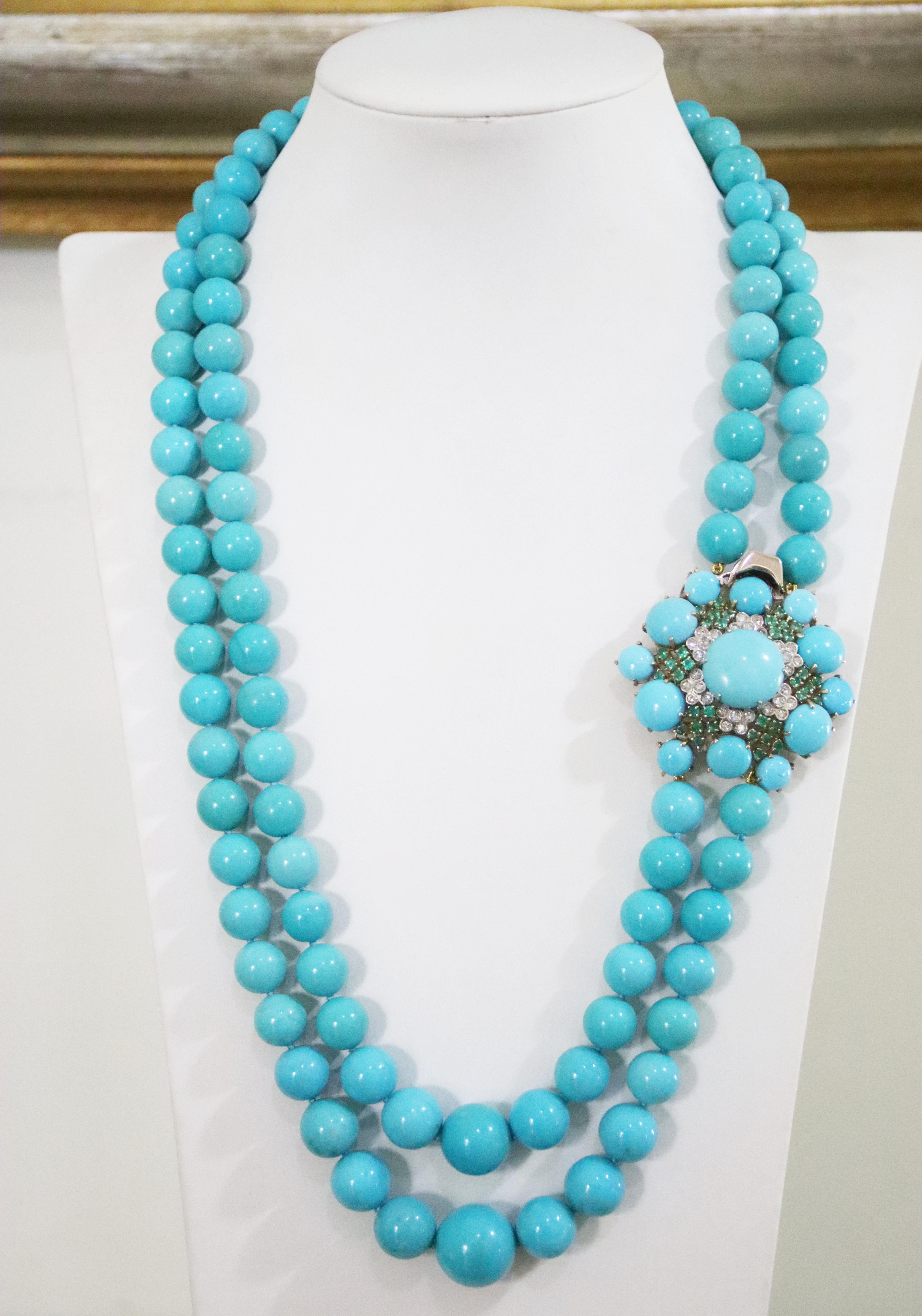 Spectacular necklace of natural authentic turquoise from Arizona with two delicately threaded strands enriched by a large 18-karat gold clasp handmade to create an elegant look, studded with diamonds and emeralds that form many small flowers and by