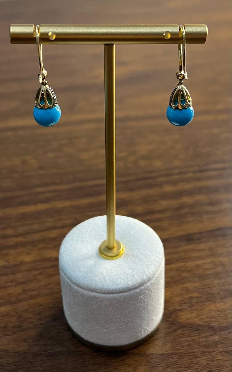Elevate your style with these captivating drop earrings.

Crafted with a vibrant turquoise bead, each earring is adorned with an intricate gold filigree cap, adding a touch of elegance.

The striking blue hue of the beads offers a bold statement,