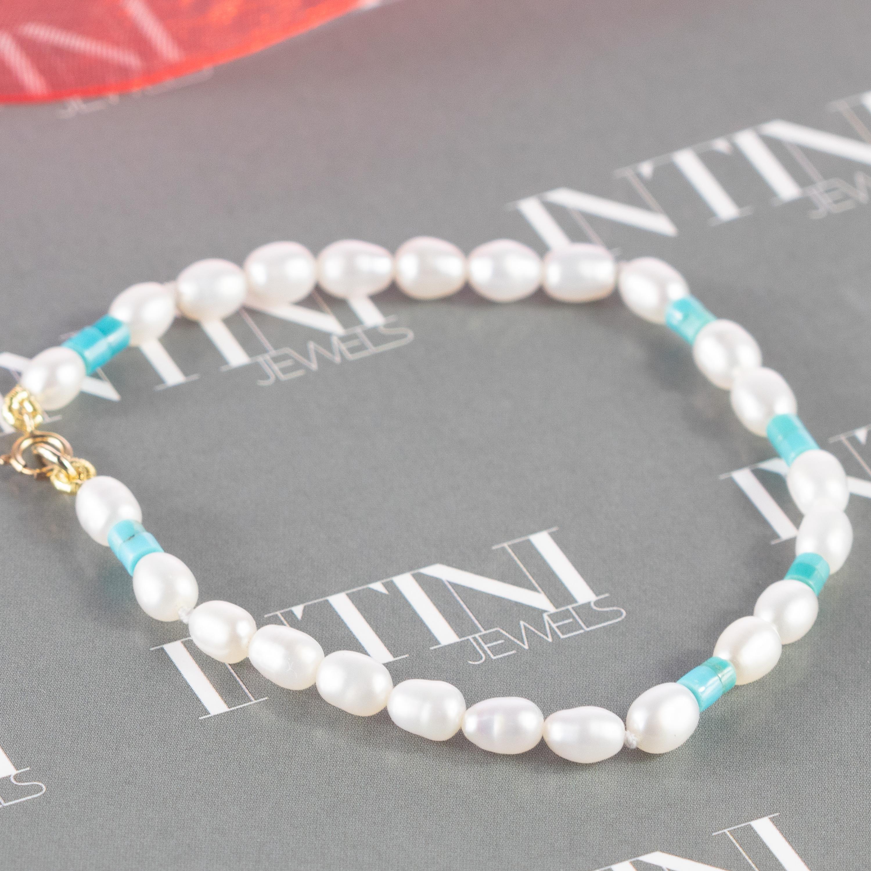 A natural turquoise and freshwater pearls bracelet full of design. A modern and delicate style for a young and fearless woman. Delight yourself with a luminous handmade jewelry. Natural precious stones beads with a 18 karat yellow gold closure. The