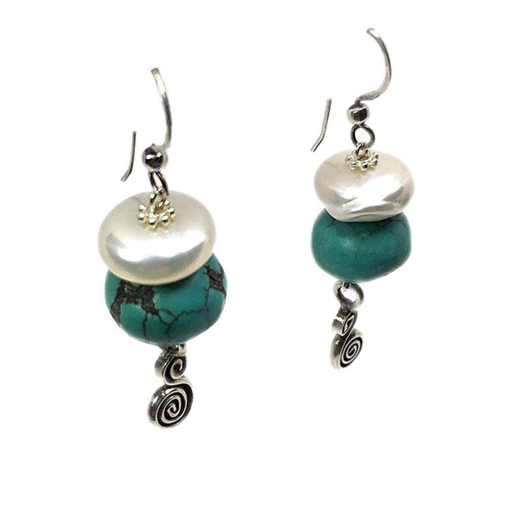 This is a pair of turquoise and freshwater pearl dangle earrings. We hand wired with unusual leather-polished turquoise and large freshwater button shaped pearls and dangling with .5 inch Hill Tribe Silver* charms. Total 2 inch drop with sterling