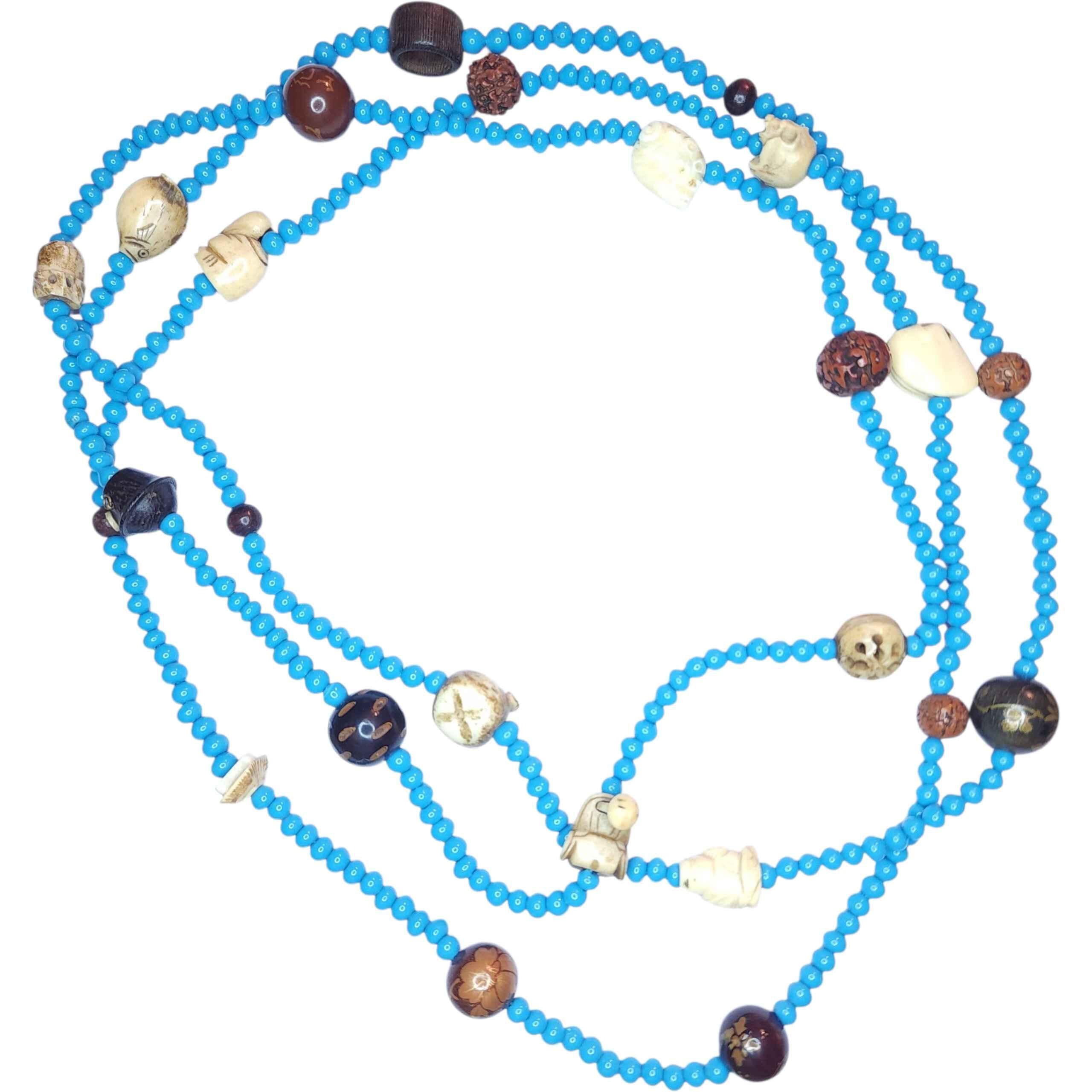 Collier extra-long en verre turquoise avec sculptures Netsuke japonaises et tibétaines anciennes et perles organiques mélangées
Véritable cabinet de curiosités unique en son genre, ce collier extraordinaire tisse des perles de verre turquoise