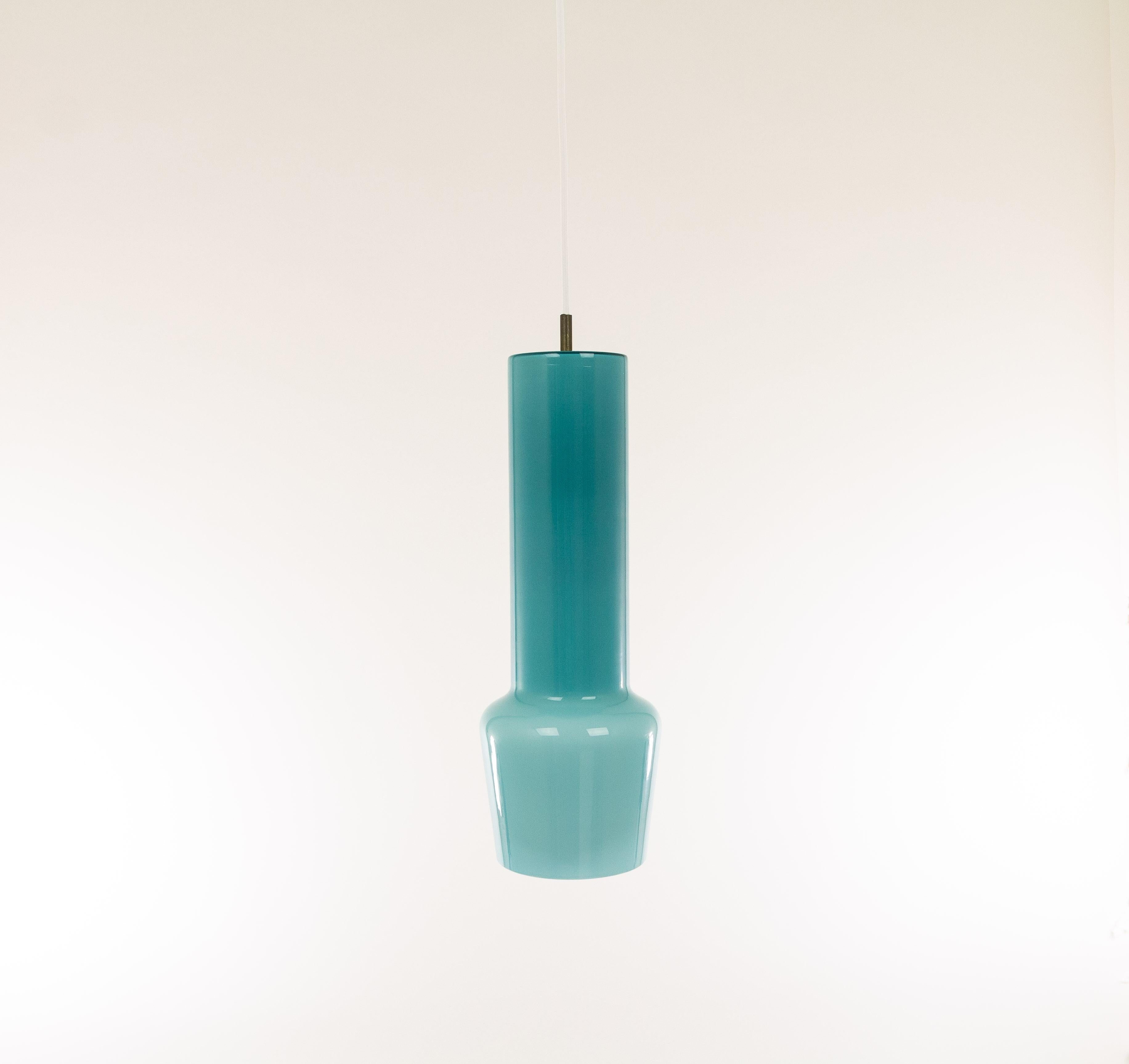 Hand blown turquoise glass pendant no. 011.11 designed by Massimo Vignelli at the start of his impressive career in design and executed by Murano glass specialist Venini. 

One of the most characteristic lamps that Vignelli designed for Venini.