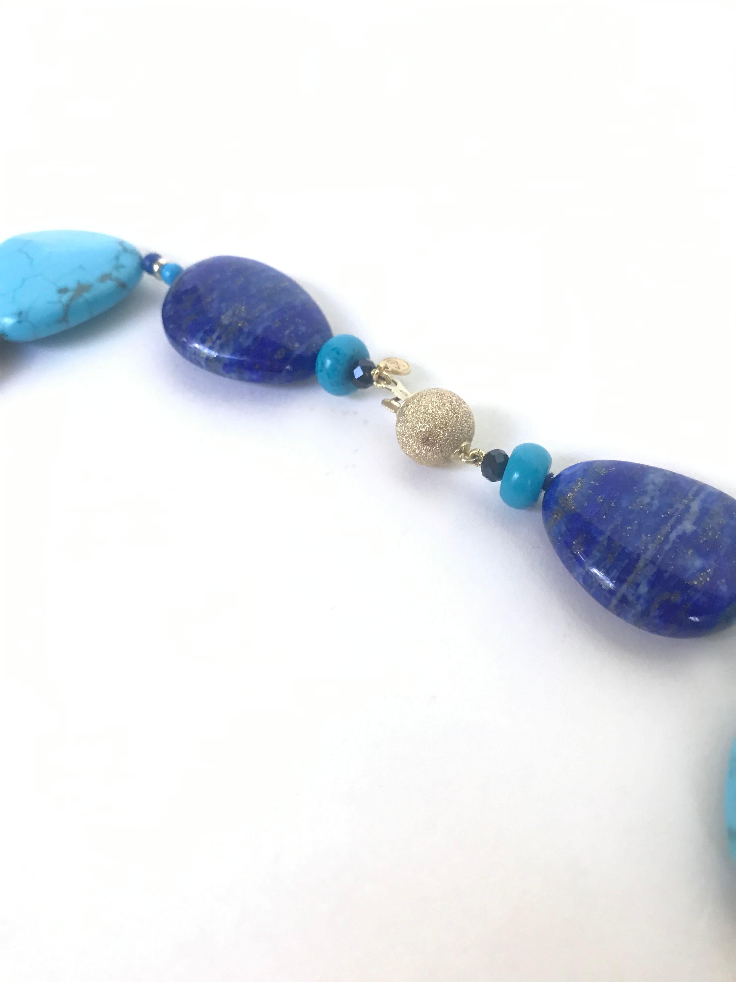 Marina J. has composed turquoise, lapis lazuli, and onyx beads together in a 47 inch necklace with a 14 k round yellow gold clasp. In between the larger beads are small 14 k yellow gold roundels adding a shine to the necklace. The brilliant blues of