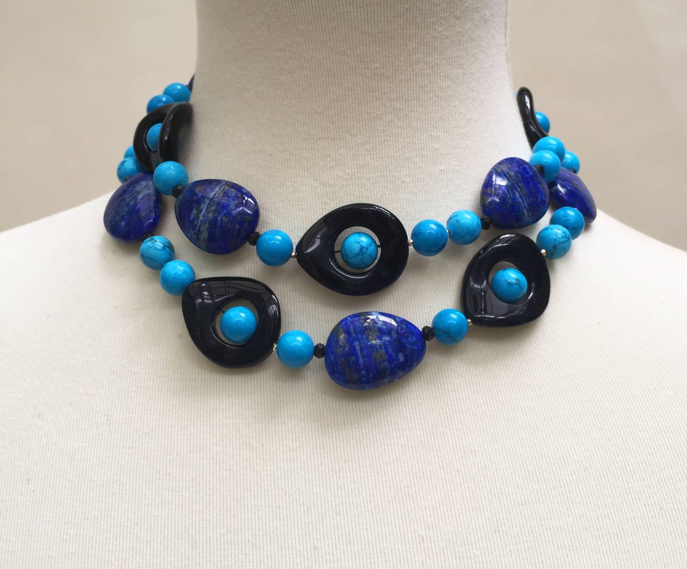 Marina J. has composed turquoise, lapis lazuli, and onyx beads together in a 33 inch necklace with a 14 k yellow gold clasp. In between the larger beads are small faceted  14 k yellow gold and black spinel beads, adding a shine to the necklace. The