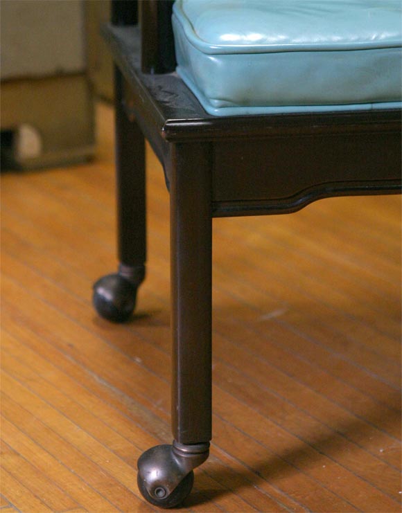 Asian style club chair on casters with original turquoise leather upholstery.