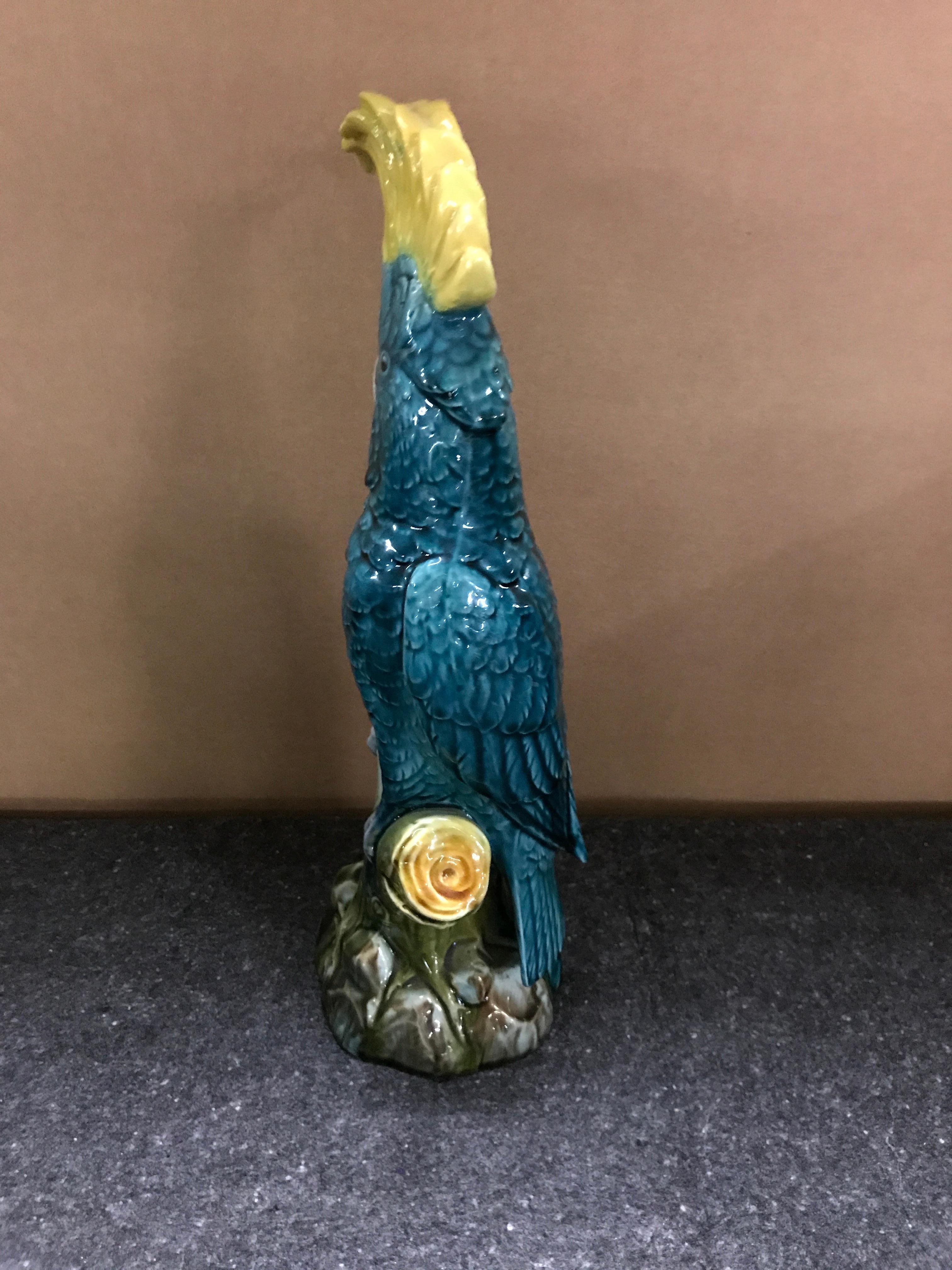 Turquoise Majolica cockatoo by Mintons, realistically modeled seated on a branch on a rockwork base.
 