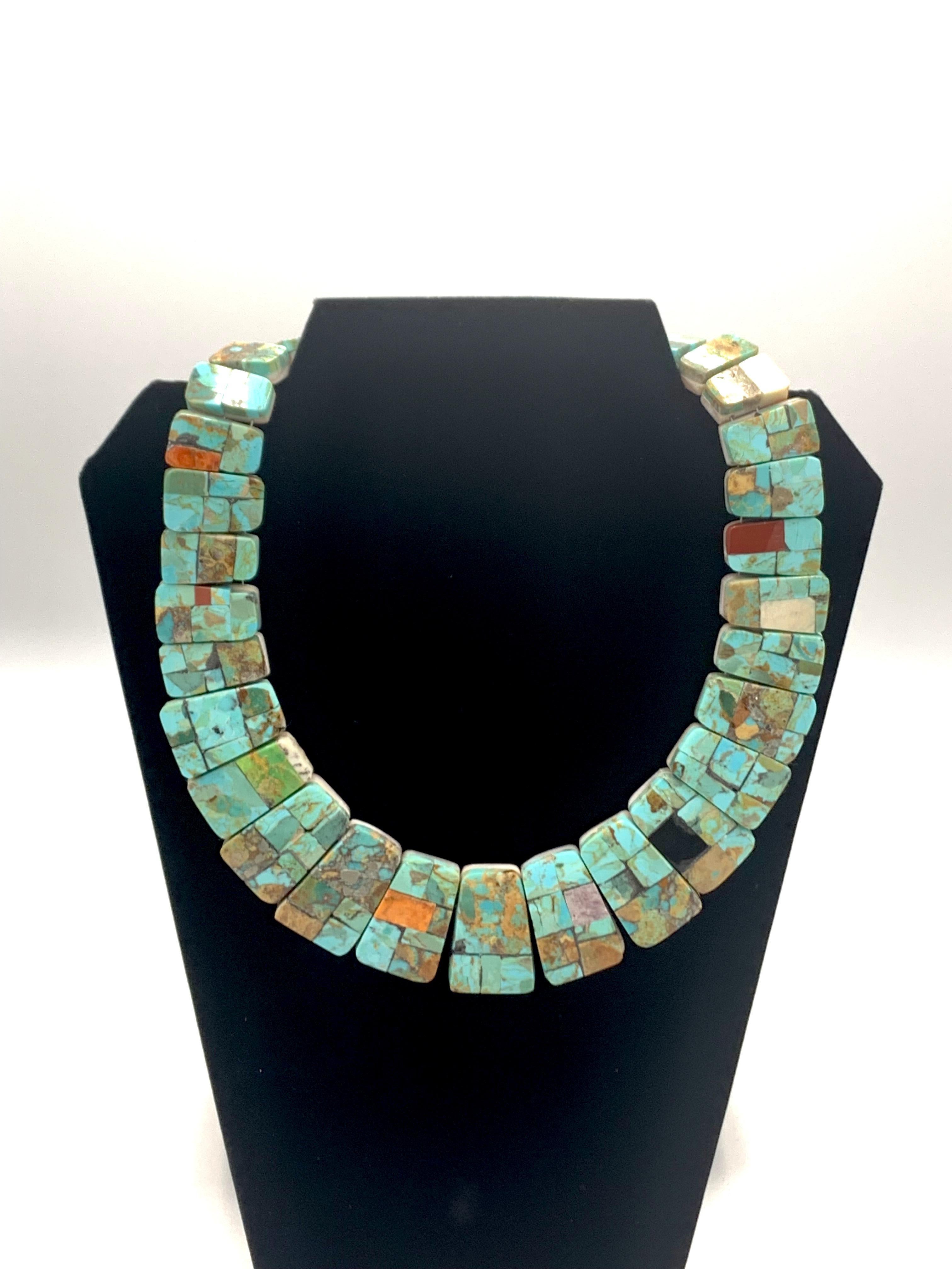 Questa squisita collana di turchese tagliata a mano dall'artista di Santo Domingo (Kewa) Jolene Bird combina magnificamente l'artigianato tradizionale con il design contemporaneo. La collana è composta da 31 segmenti rettangolari intarsiati,