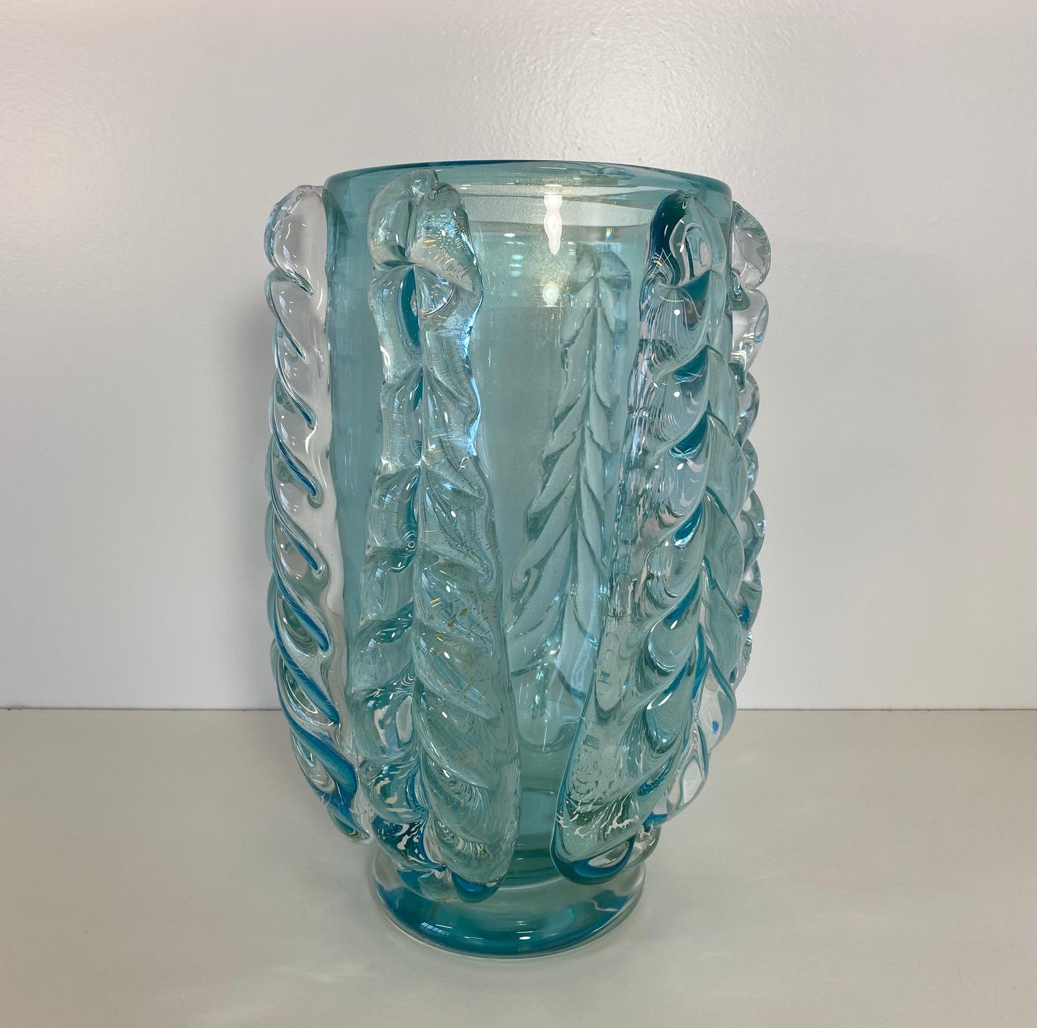 This elegant and rare vase was produced in Italy, more precisely in Murano, which is the world's capital of glass art making and crafting. 

The vase is made of turquoise Murano glass finely handmade and decorated by great glass master