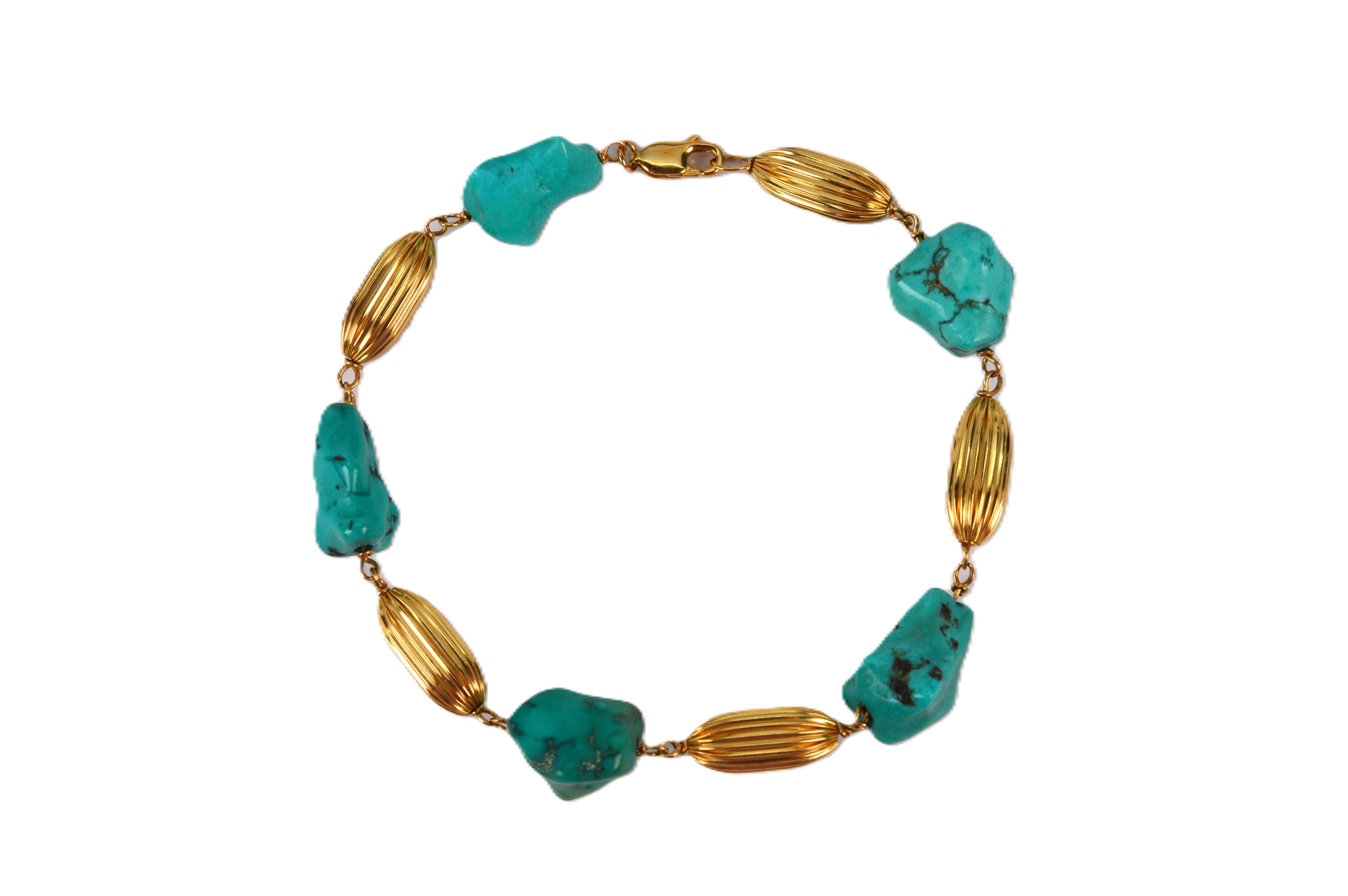 Light and bright, this attractive eight inch bracelet presents colorful polished turquoise nuggets complemented by alternating 14 karat yellow gold oval bead links textured with a ribbed detail. The naturally shaped stones, ranging approximately