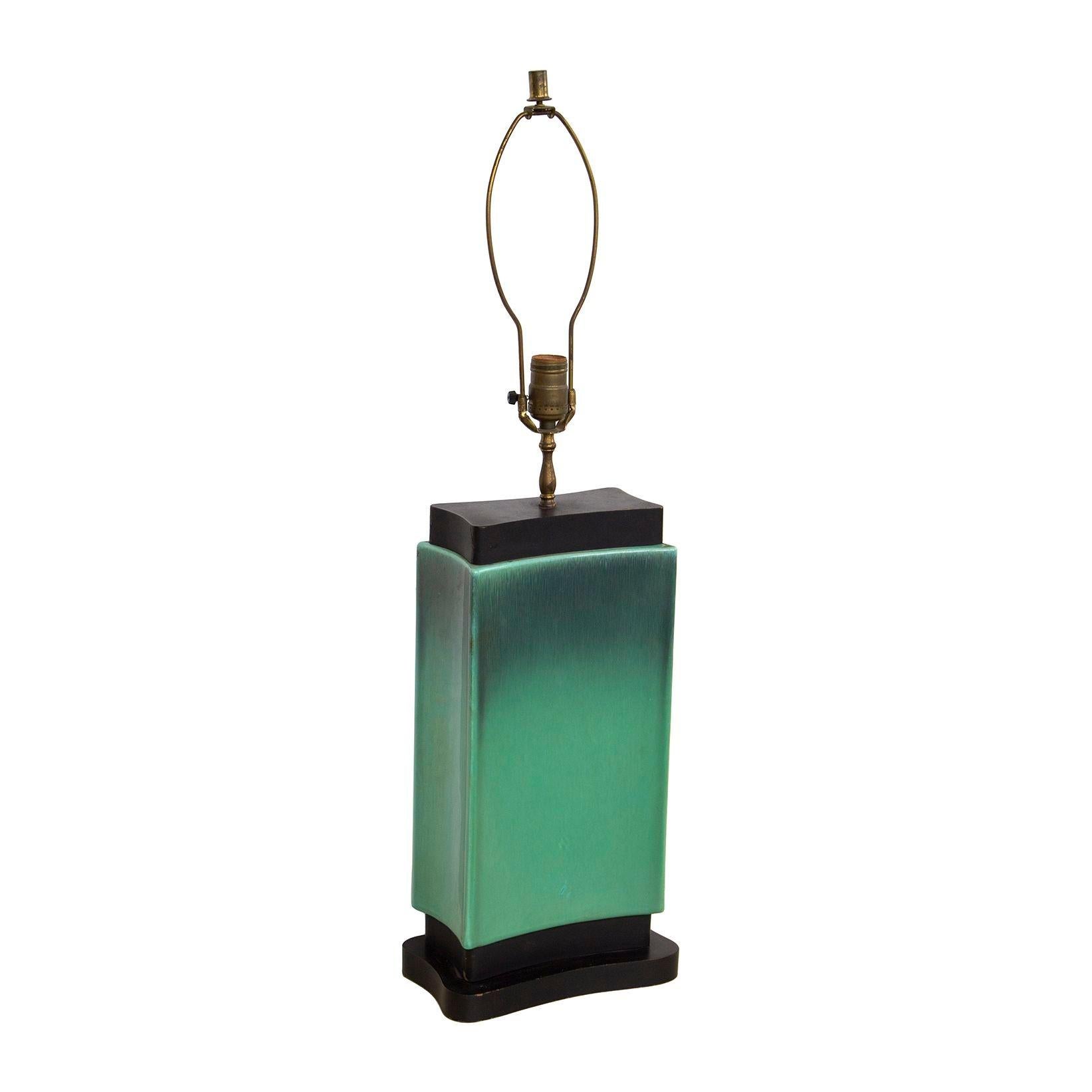 USA, 1940s
Beautiful and unusual art deco / midcentury modern table lamp in an ombre turquoise glaze with ebonized, curving wooden fittings. Lamp comes with original shade, which is in poor condition, but can be used for a model on the size and