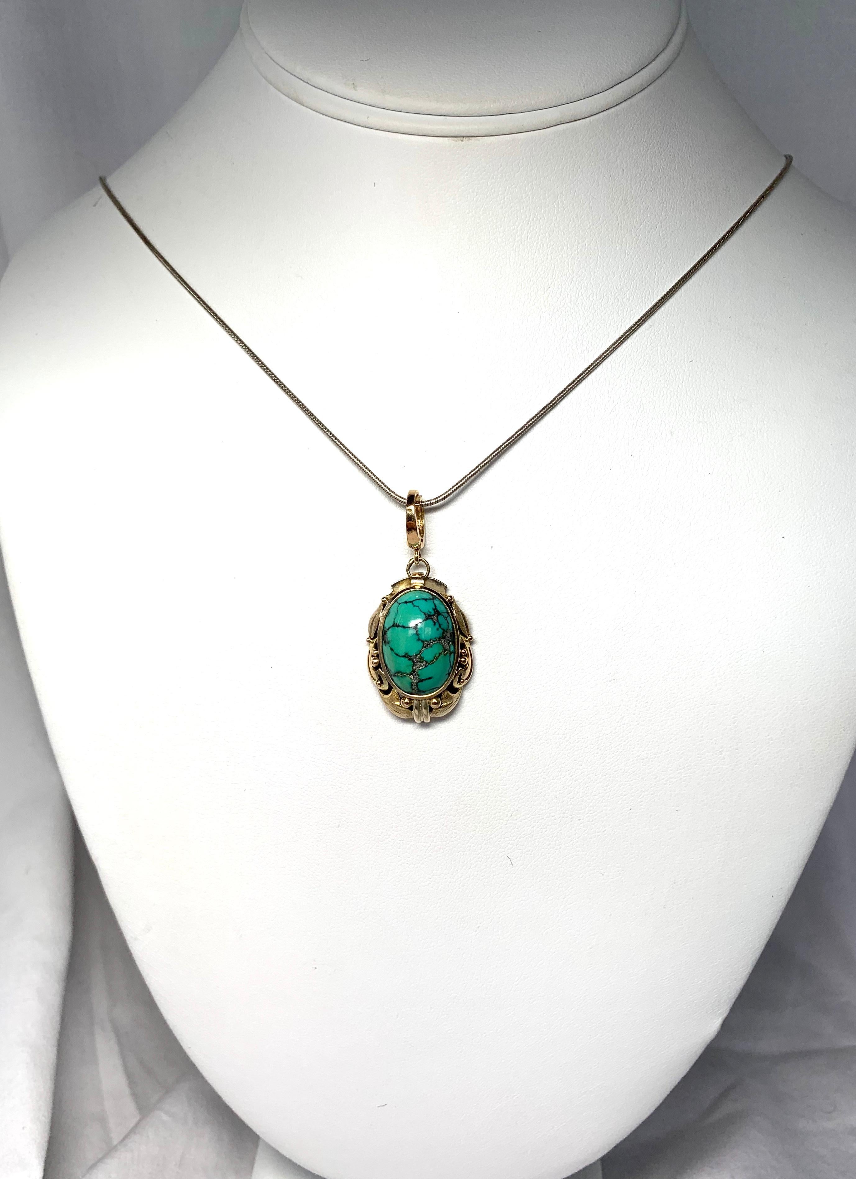 This is a stunning pendant with a gorgeous oval Turquoise of great beauty!  The oval Turquoise is set in a wonderful 14 Karat Gold open work setting.  The pendant hangs from a very fine bale that can open and close.  The quality of the workmanship