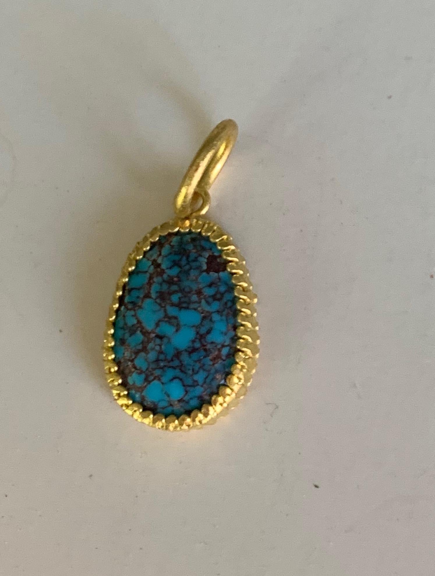 Antique Turquoise pendant et in a scalloped setting in 22 Karat gold. Lovely stand alone or included with other charms.
The pendant hangs 1 inch 1/16