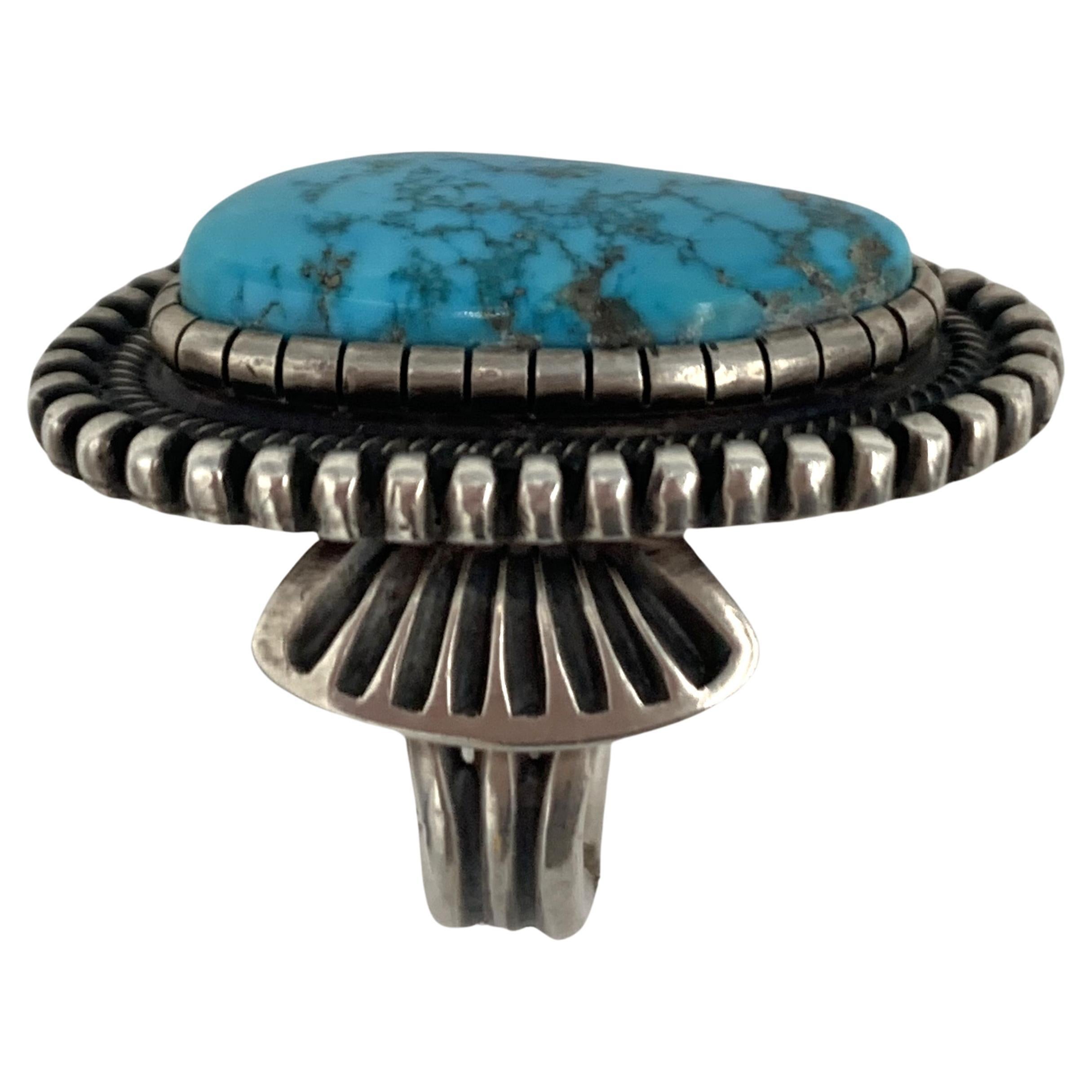 Turquoise Ring with Sterling Silver Setting made by Navajo Silversmith Terry Martinez.

The silver work on this ring is made in a traditional Navajo manner. Terry hand stamped deep Navajo designs around the entire ring.

Terry Martinez,