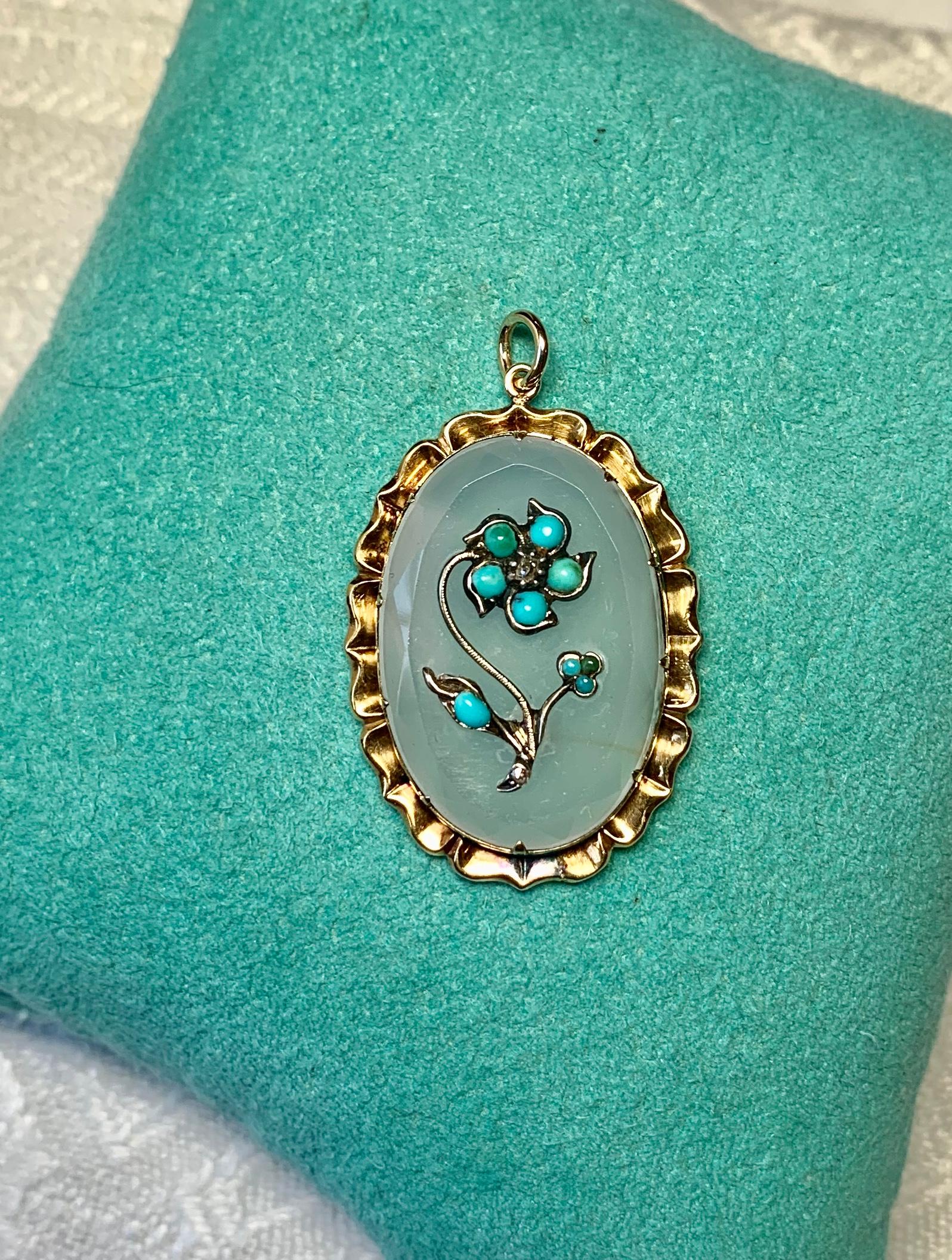 A STUNNING VICTORIAN TO ART NOUVEAU PENDANT IN BEAUTIFUL CARVED OVAL FACETED CHALCEDONY WITH A ROMANTIC 15K GOLD FULLY MODELED FLOWER MOTIF SET WITH 9 PERSIAN TURQUOISE FLOWER PETALS AND A ROSE CUT DIAMOND CENTER.  THE CHALCEDONY IS SET IN A LOVELY