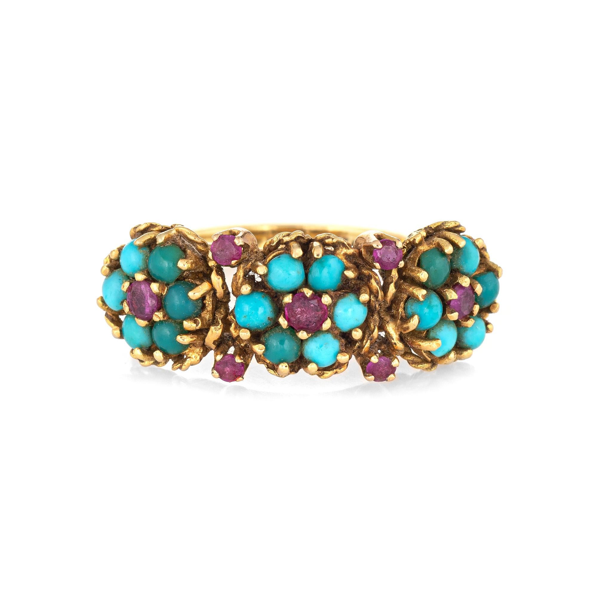 Stylish vintage turquoise & ruby ring (circa 1960s) crafted in 18 karat yellow gold. 

Turquoise cabochons each measure 2.5mm, accented with 7 rubies that total an estimated 0.22 carats. The turquoise does show some discoloration from age.  

The
