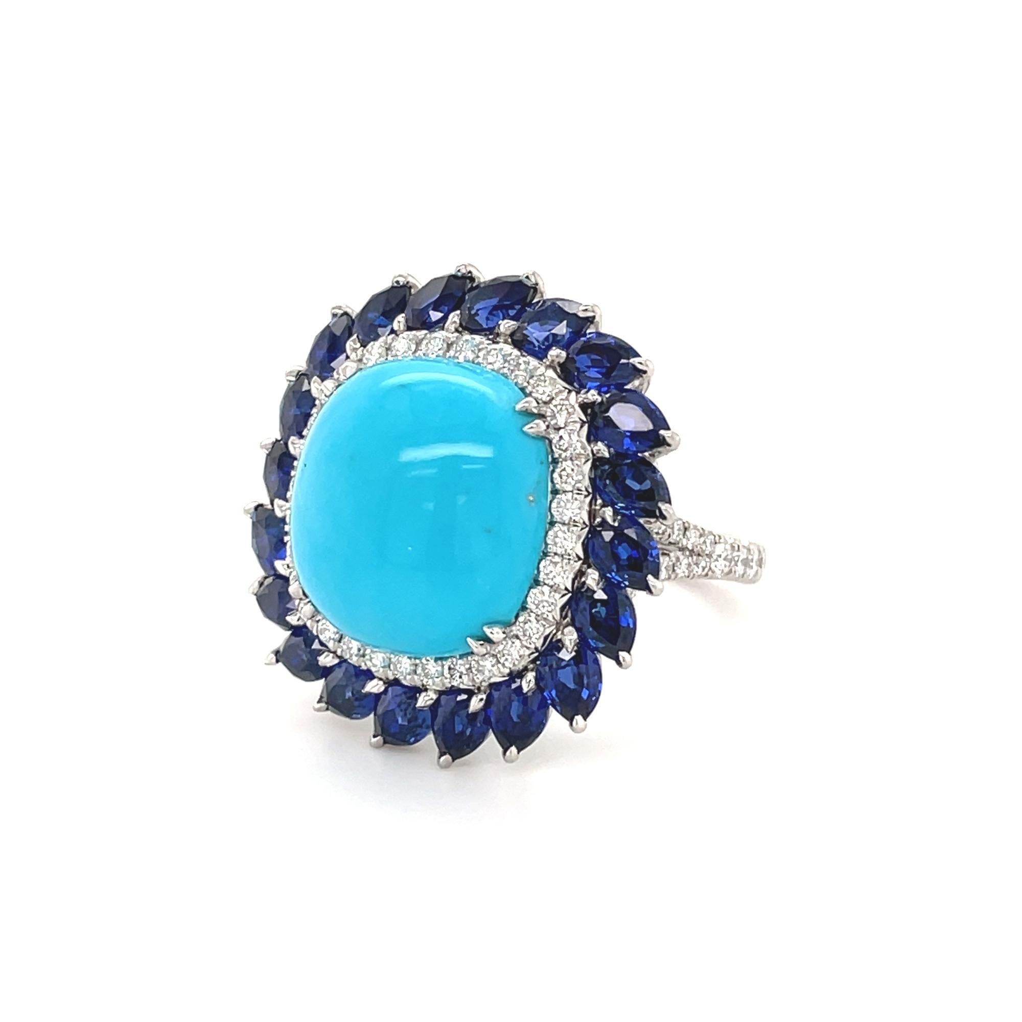 This beautiful cocktail ring features a prong set center blue cabochon turquoise stone weighing 11.60cts. Surrounded by a halo of dazzling round brilliant cut diamonds weighing 1.20cts and pear shaped Blue Sapphires in prong setting weighing