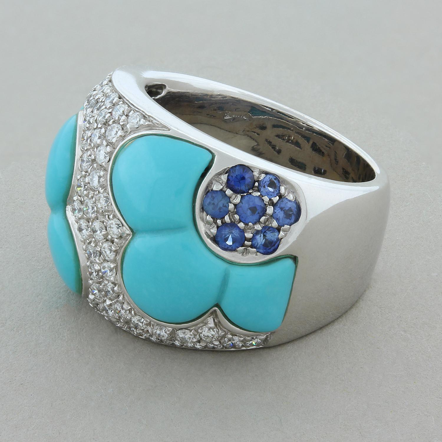 This feminine ring features 11.40 carats of the esteemed turquoise shaped in two half flowers. The pistil of the flowers features 0.60 carats of round cut blue sapphires. The flowers are separated by 1.00 carat of round brilliant cut diamonds set in