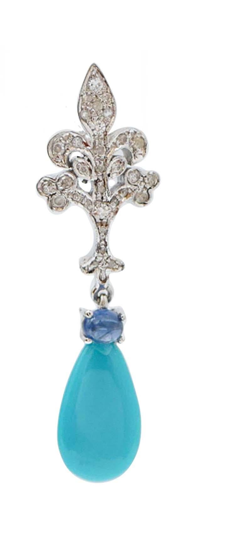 Incredibili orecchini in oro bianco 14 kt con struttura montata con diamanti per tutta la lunghezza. Come ciondolo, un turchese e, su di esso, uno zaffiro.
Questi orecchini sono stati realizzati totalmente a mano da maestri orafi italiani e sono in