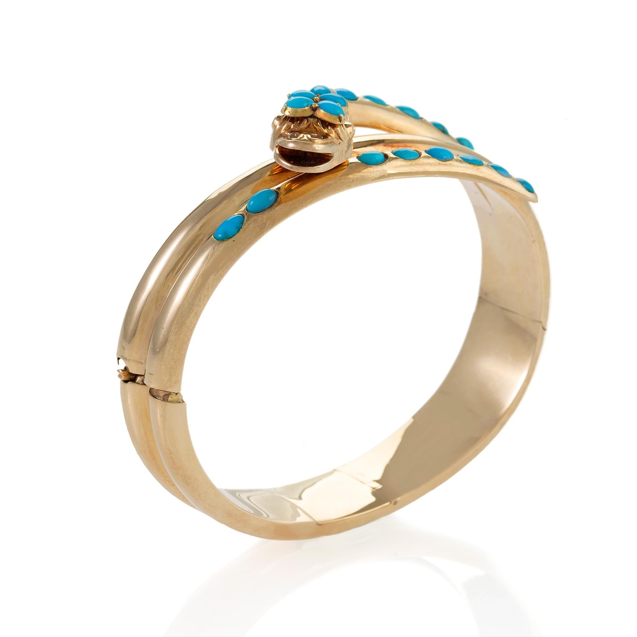 This Victorian serpent bangle bracelet is composed of gold and turquoise. Designed as a triple coiled snake and floral motif, the head and frontal coils are highlighted by oval and pear-shaped turquoise cabochons. With its multiple polished coils