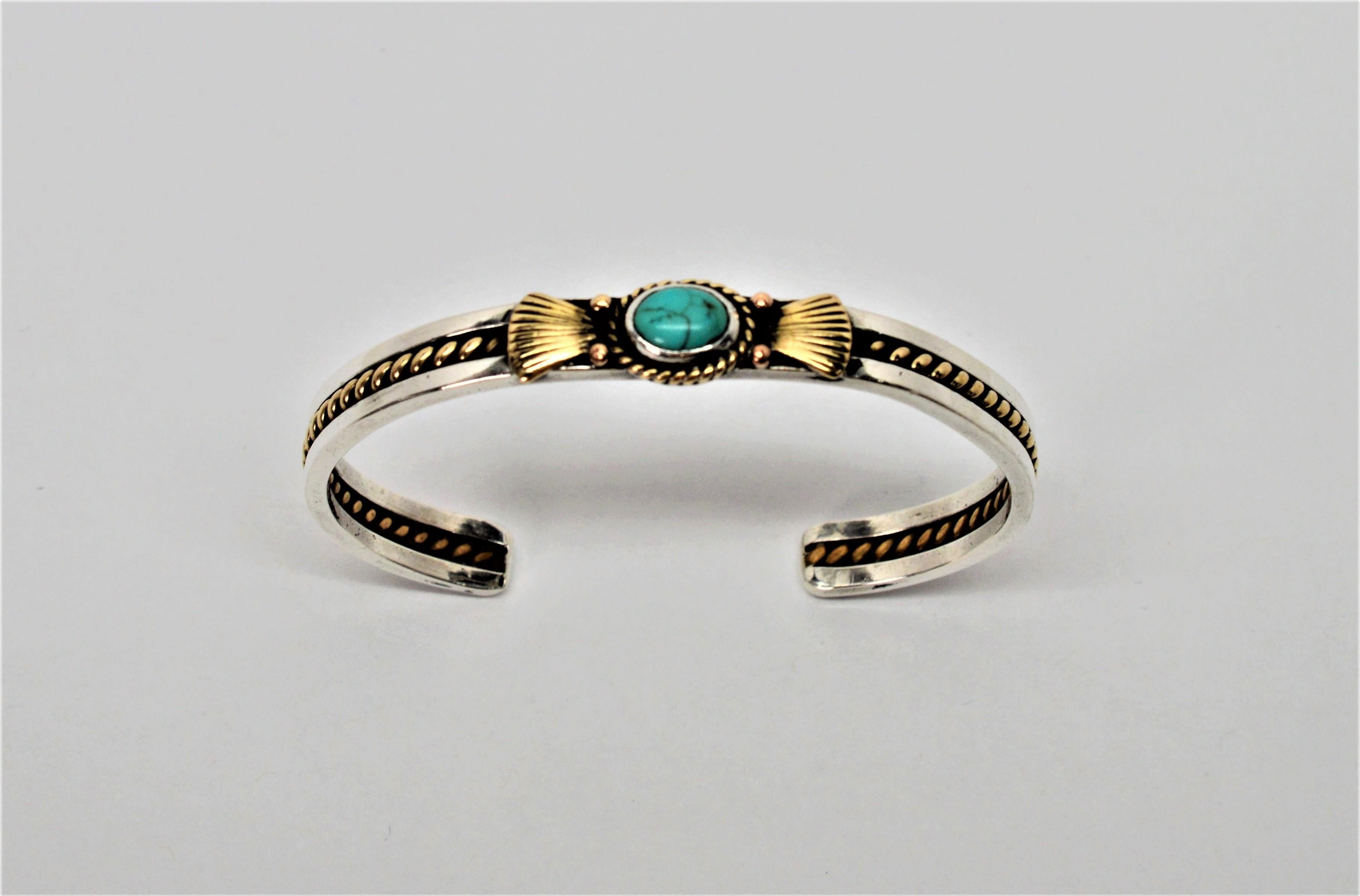 If you are a fan of Southwestern style jewelry, you will love this vintage cuff bracelet. The two toned cuff features a natural turquoise stone cabochon that is bezel set in sterling and accented with an attractive shell patterned ten karat 10K
