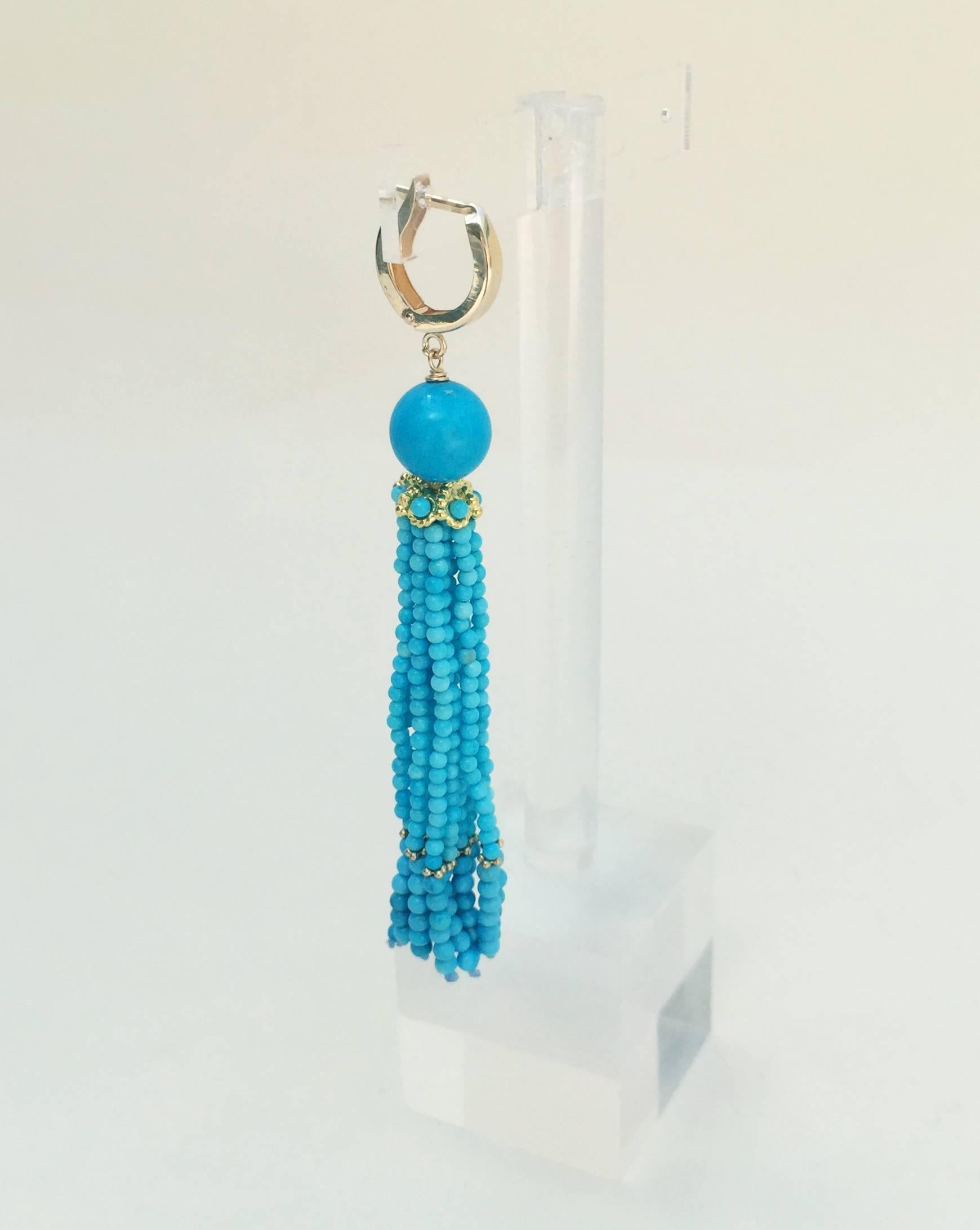 A large turquoise bead starts off these earrings followed by a gold small cup. These turquoise tassel earrings are highlighted by 14k yellow gold beads. The 14k yellow gold lever backs accentuates the elegance and brilliant blue turquoise earrings. 