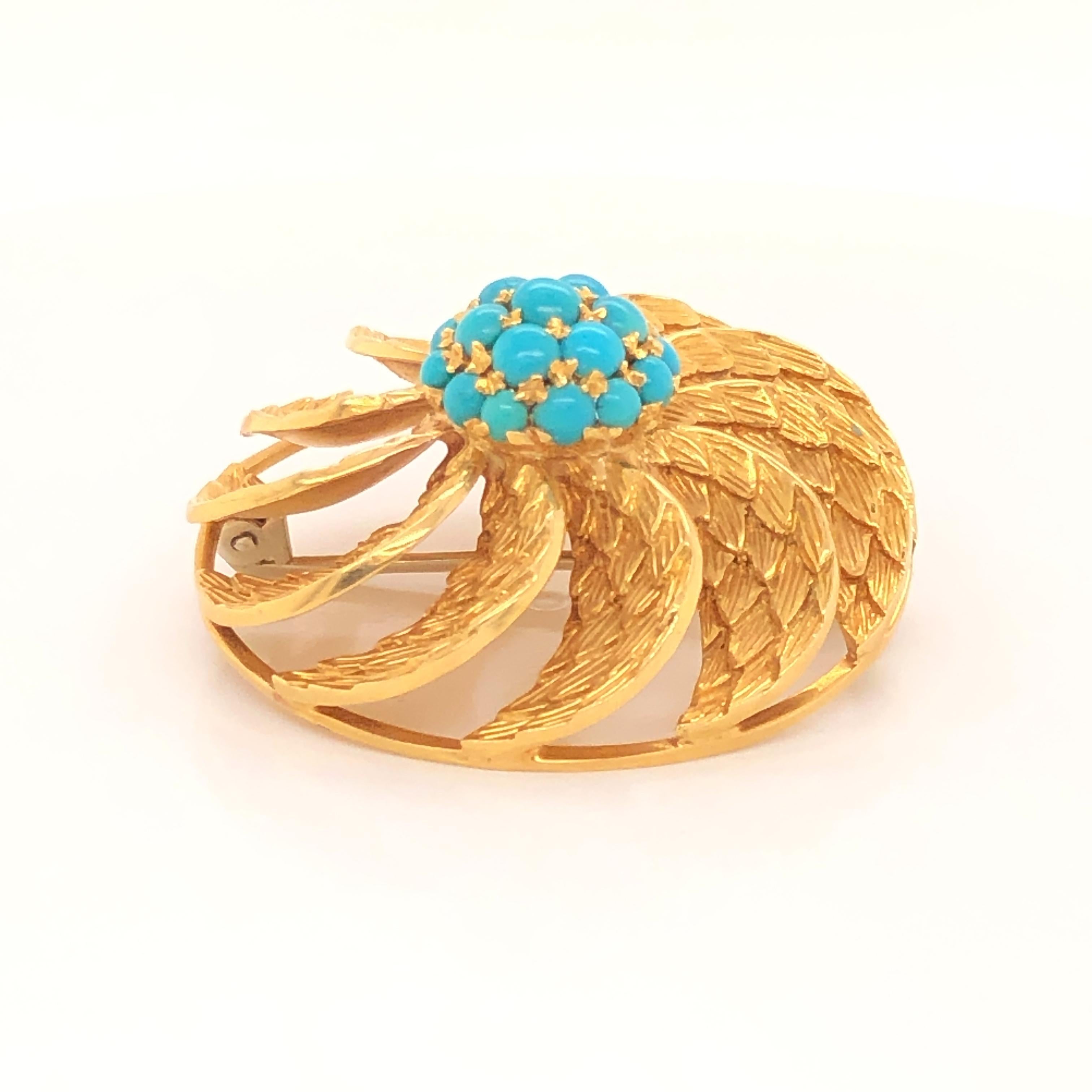 Finely made Italian three dimensional 18k yellow gold brooch pendant featuring a prong set turquoise center section amongst swirling leaves.  The back has a loop that flips up and allows for the brooch to be used as a pendant.  The loops turns so it