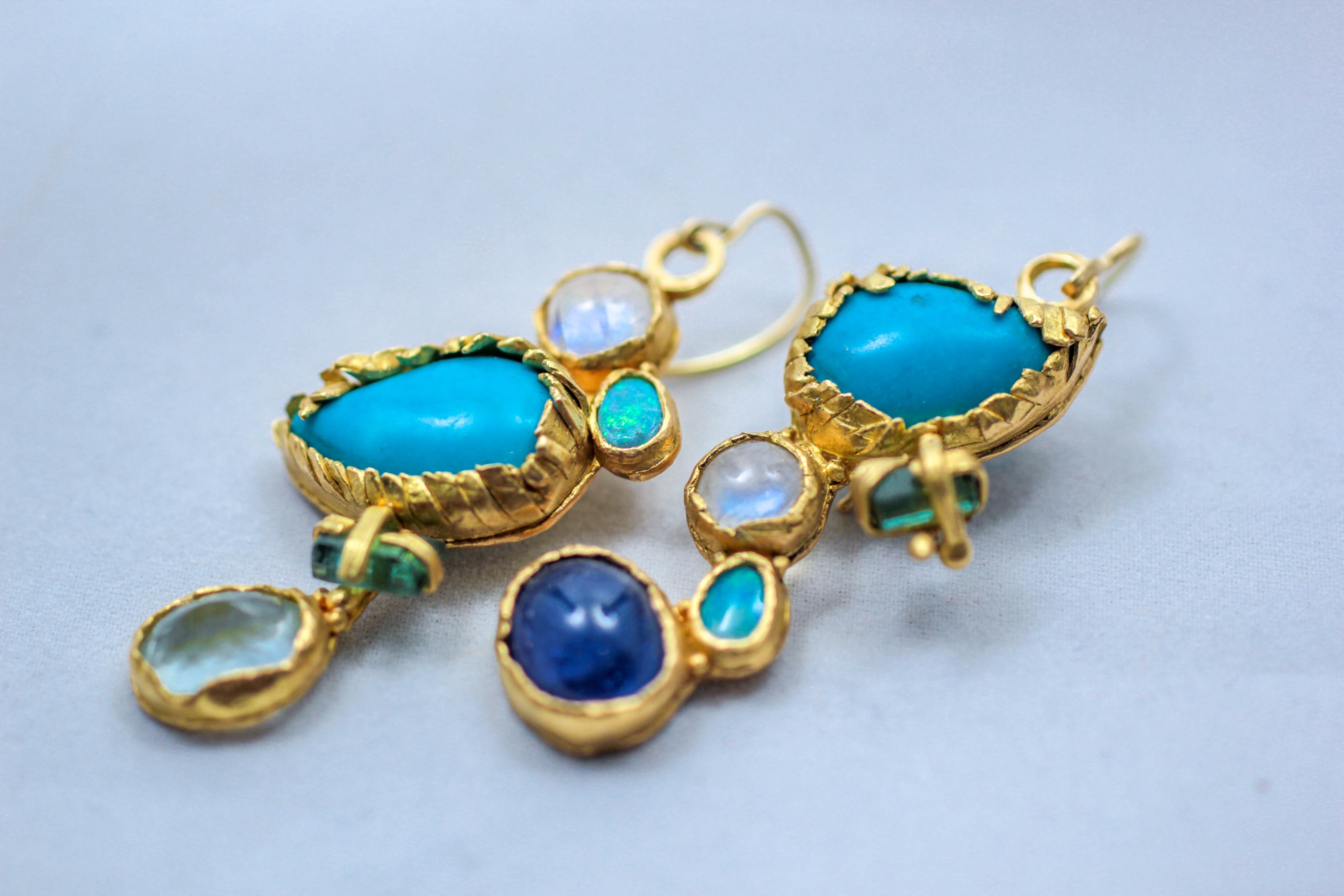 Oiseaux, boucles d'oreilles pendantes. La turquoise, la pierre de lune, les cristaux de tourmaline, l'opale et la tanzanite sont sertis dans un chaton en or 21K. Unique en son genre, fait à la main. Féminines et exotiques, elles ne manqueront pas