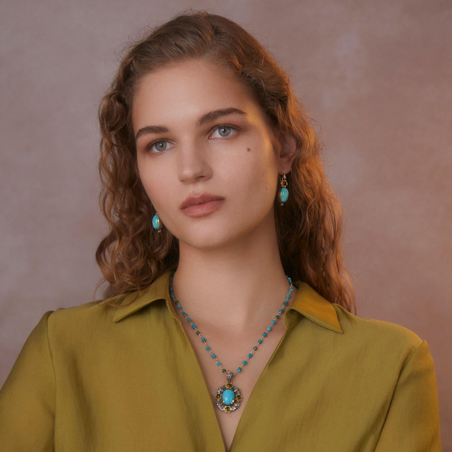 

Un bellissimo ciondolo in turchese fatto a mano e unico nel suo genere. Questo stand out  Il ciondolo ha una gemma centrale di turchese circondata da tormaline verdi e sormontata da un diamante. 

È realizzato in oro 18k e argento sterling