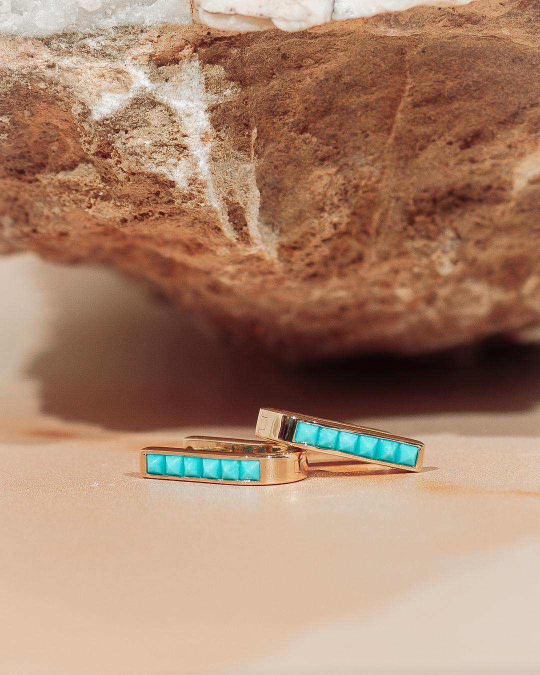 Ces boucles d'oreilles en forme de U sont une version moderne de la boucle d'oreille. Elles sont en or jaune 14 carats, mesurent 15 x 10 mm et ont un poids substantiel. La paire comporte 12 turquoises carrées en serti inversé de 0,93 ctw. Ces