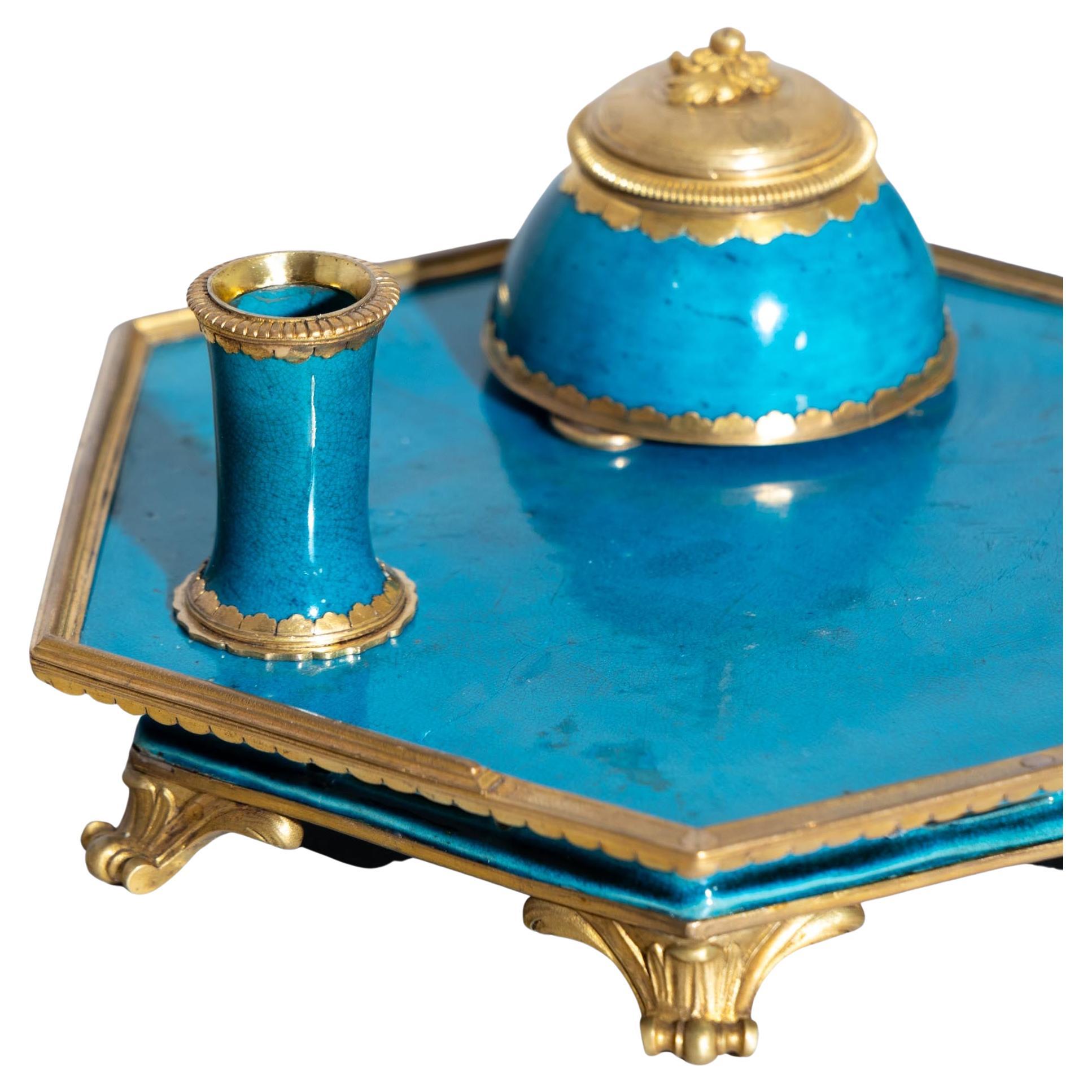 Hexagonal porcelain desk set with turquoise blue glaze with fine craquelure. The tray stands on bronze rocaille feet and supports a bell-shaped inkwell with lid and a conical pen holder. The bronze mountings are European additions.