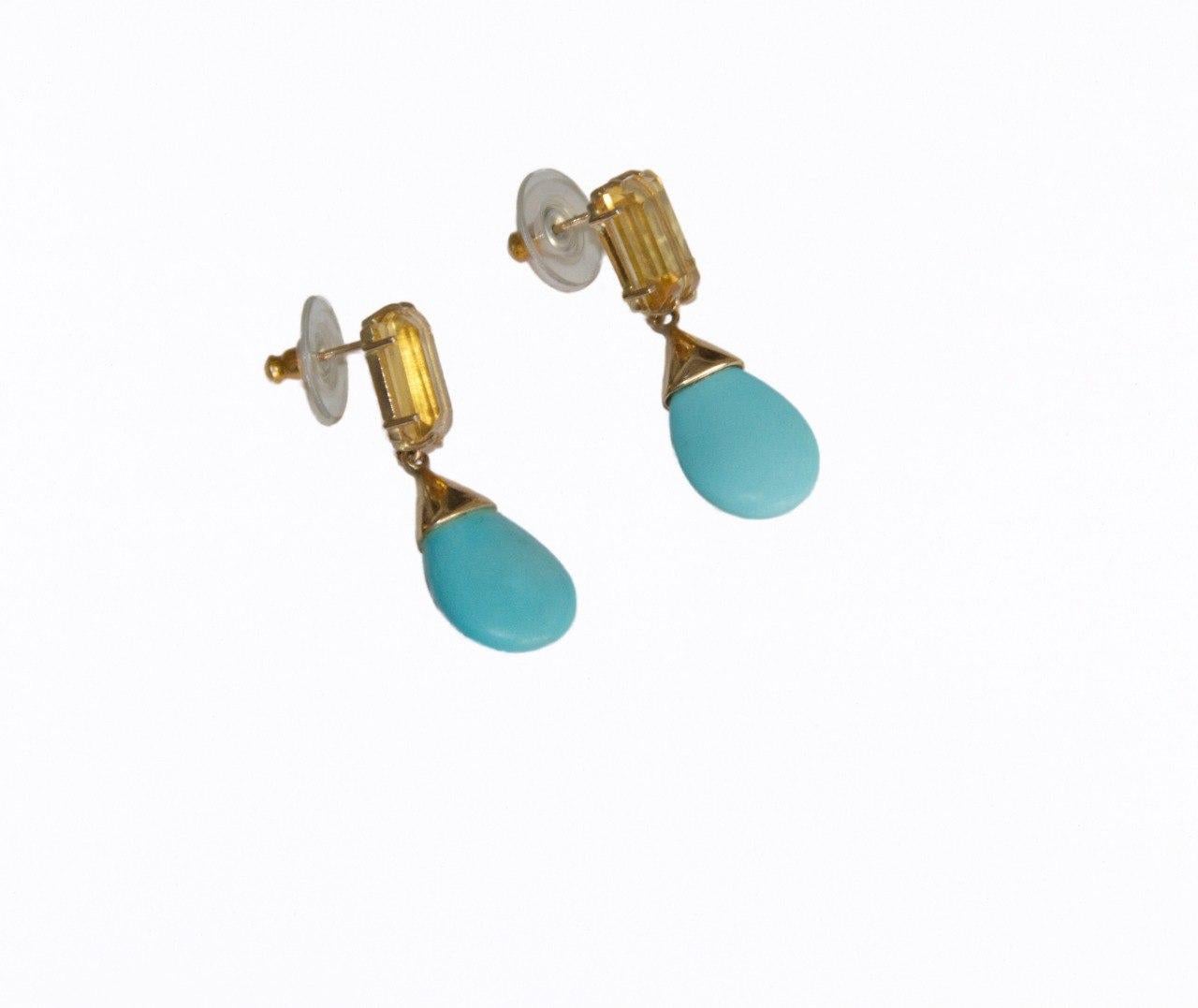 This elegant earring is a true celebration of vibrant color and refined craftsmanship, making it a standout addition to any jewelry collection. Crafted from luxurious 9-karat yellow gold, the design features a striking drop-cut turquoise that