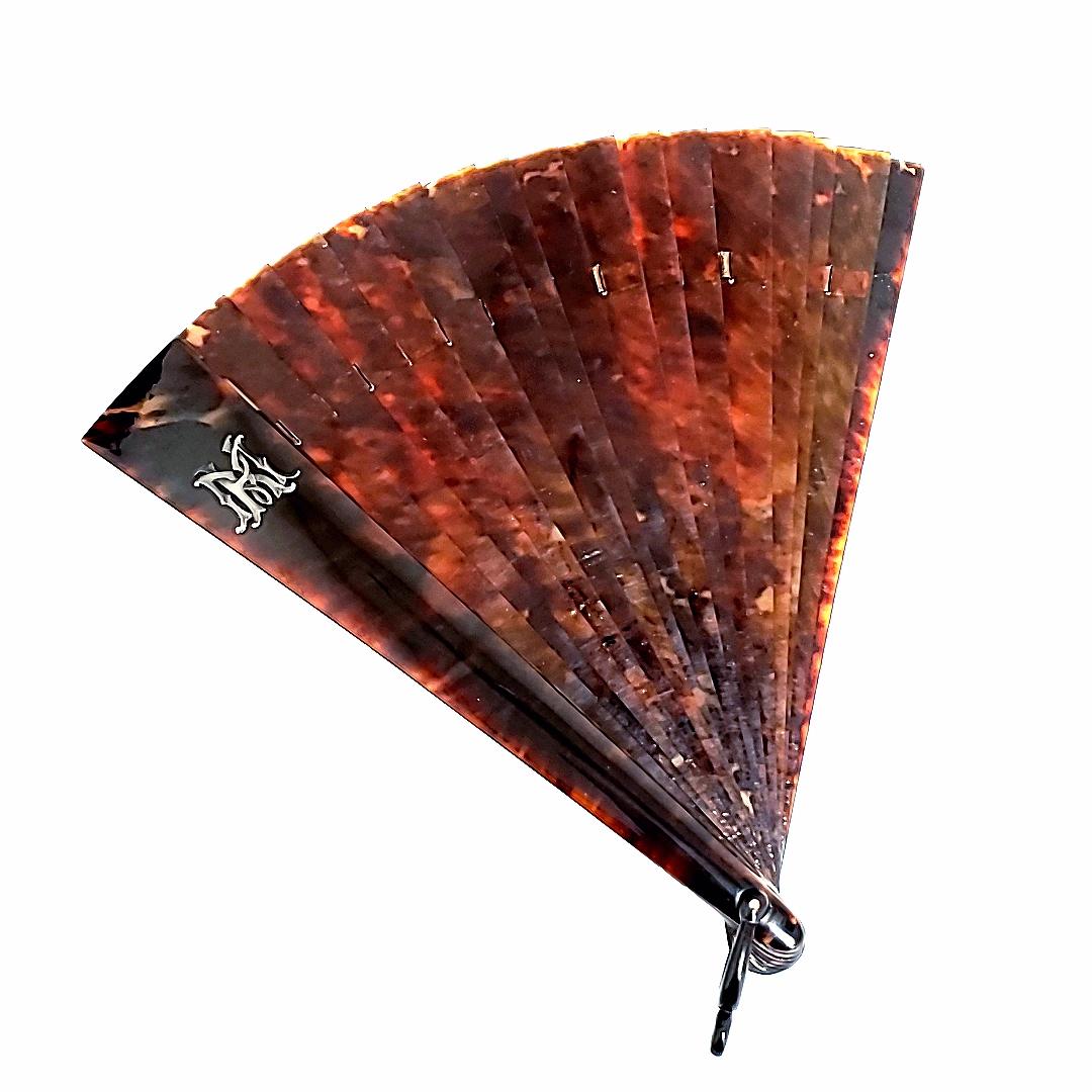 It is assumed to be vintage French (Brise) fan from 1875 - 1889


Period: 1870 - 1900

This tortoiseshell fan is a rare collector's piece that originated in Europe. 

It is from French Austria, or Germany. 

It is lined by a silk tread and has the