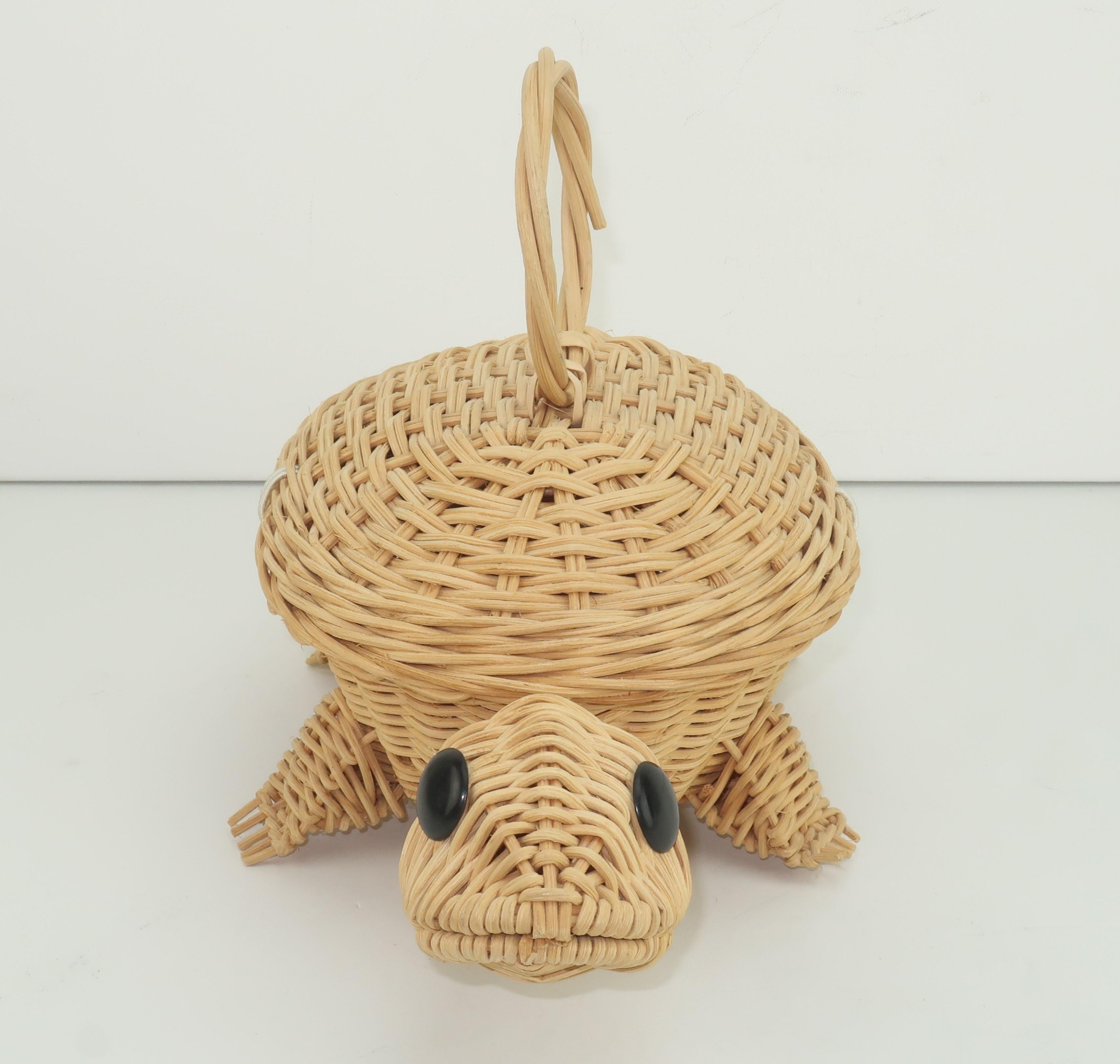 Adorable natural wicker basket handbag in the shape of a turtle on the move.  It has a ring shaped top handle with a black button and white elasticized cord closure which opens to a small but roomy interior.  He is the perfect accessory for a