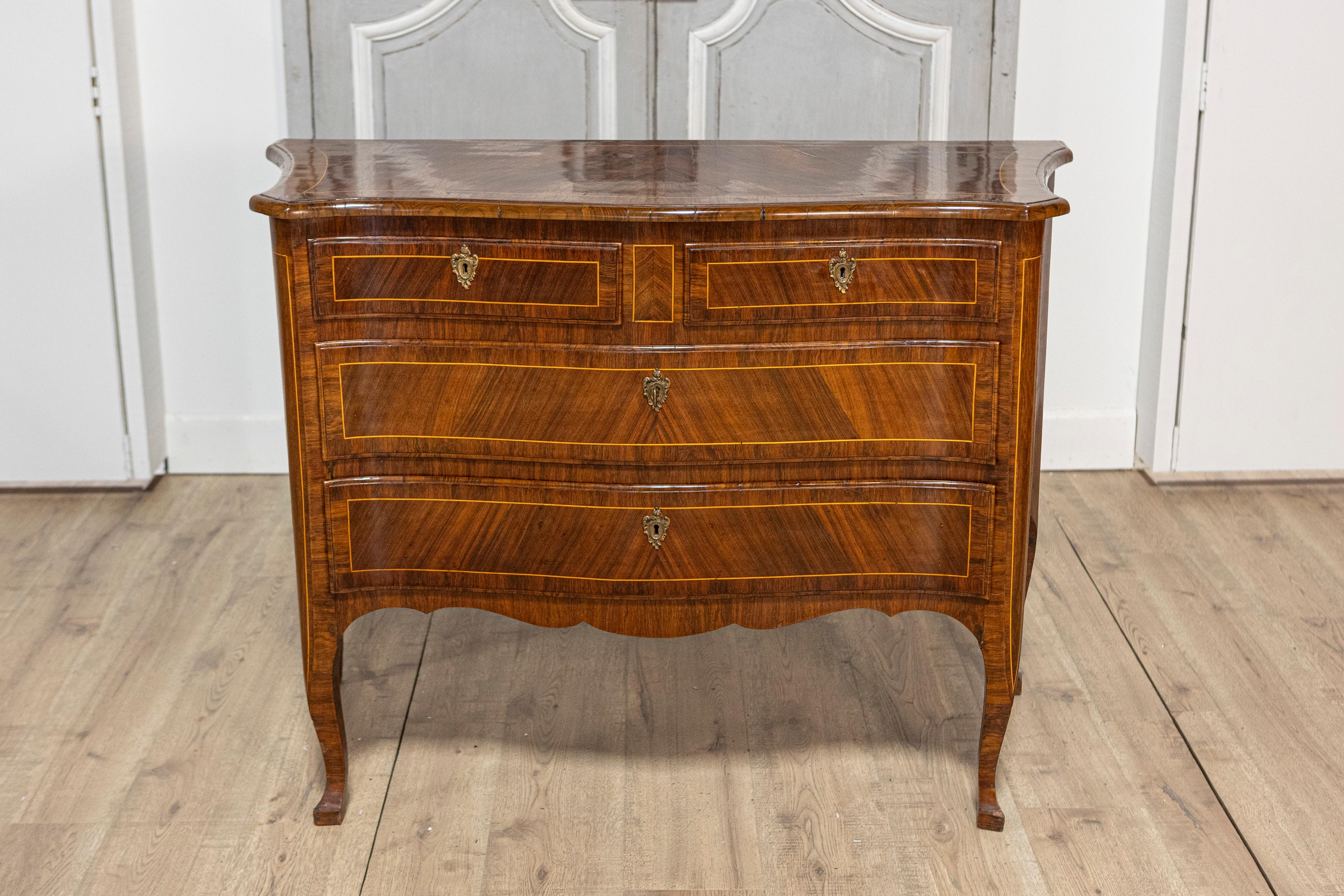 A Tuscan walnut and mahogany commode from circa 1890 with four drawers, banded inlay and bronze hardware. This exquisite Tuscan walnut and mahogany commode from circa 1890 showcases the refined elegance and masterful craftsmanship of the late 19th