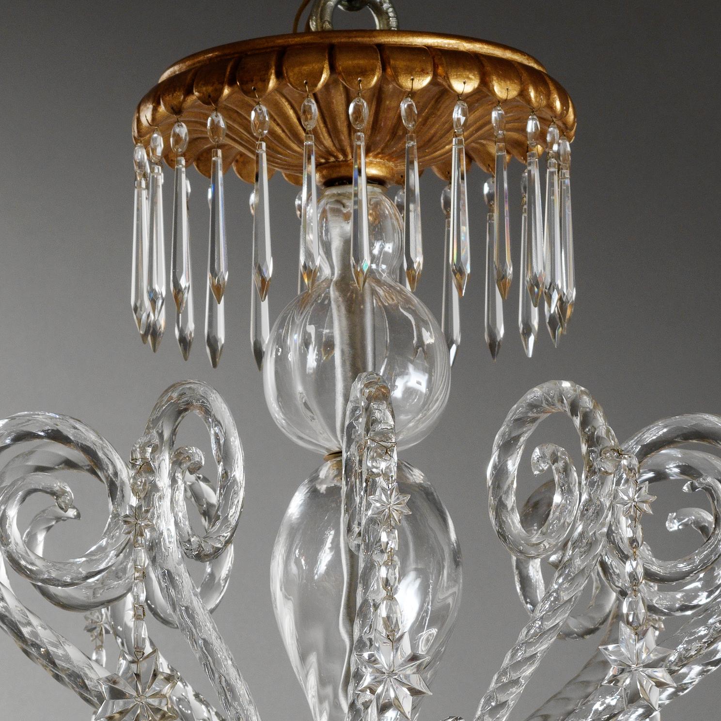 Elégant lustre italien de style Rococò par Gherardo Degli Albizzi, en verre soufflé, de couleur transparente avec bois doré. La couronne supérieure est ornée de nombreux cristaux, tandis que la coupe du milieu contient de nombreuses pastorales d'où
