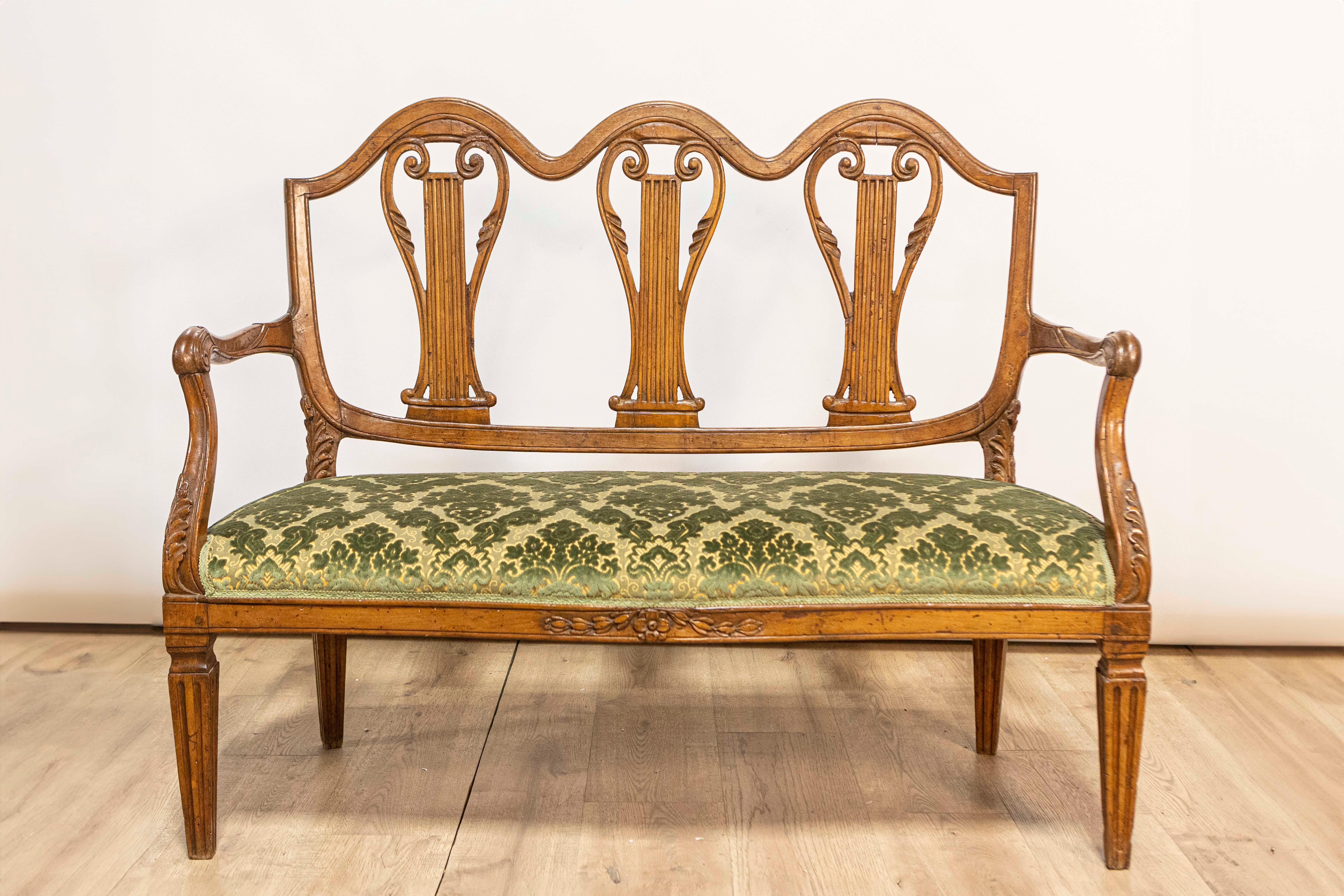 Canapé en noyer Florentine du XVIIIe siècle provenant de la Villa Fioravanti, avec des motifs de lyre sculptés, des accoudoirs en volutes et des pieds fuselés et cannelés. Cet exquis canapé en noyer toscan du XVIIIe siècle, provenant de l'illustre