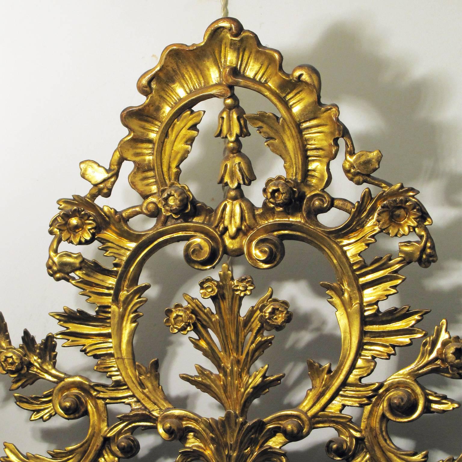 A Tuscan Louis XVI mirror in a carved and leaf gilded wooden frame with floral scrolls, acanthus leaf reliefs and original silvered mirror plate. Made in Lucca at the late 18th century, in the style of Louis XVI.