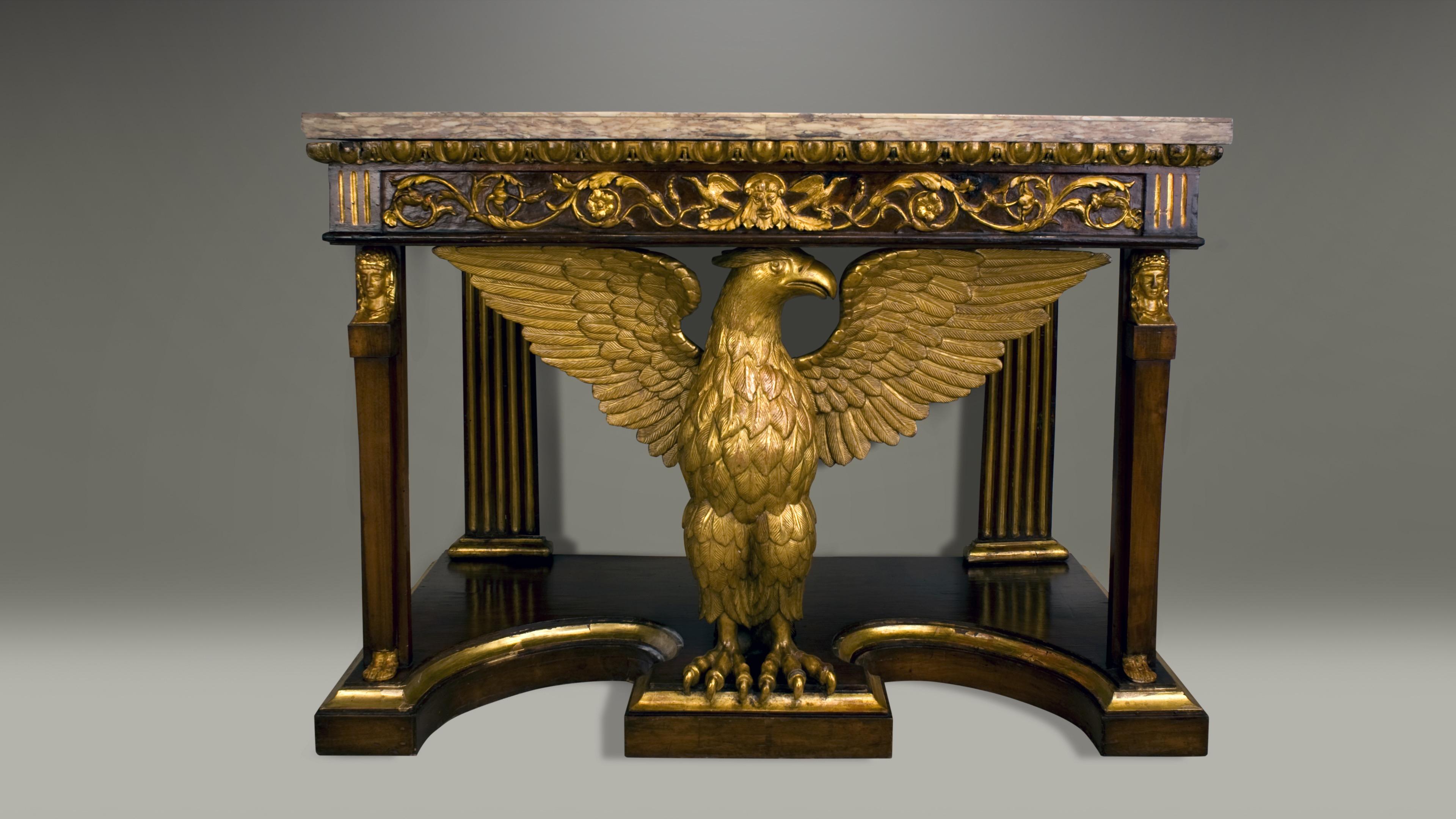 A rectangular Onyx (Onda Marino) top sits above an ornately carved frieze, circa 1820. Fluted rear columns and tapered front columns with carved and gilt heads and feet provide support. Ultimately depicted is a centered elaborately carved giltwood