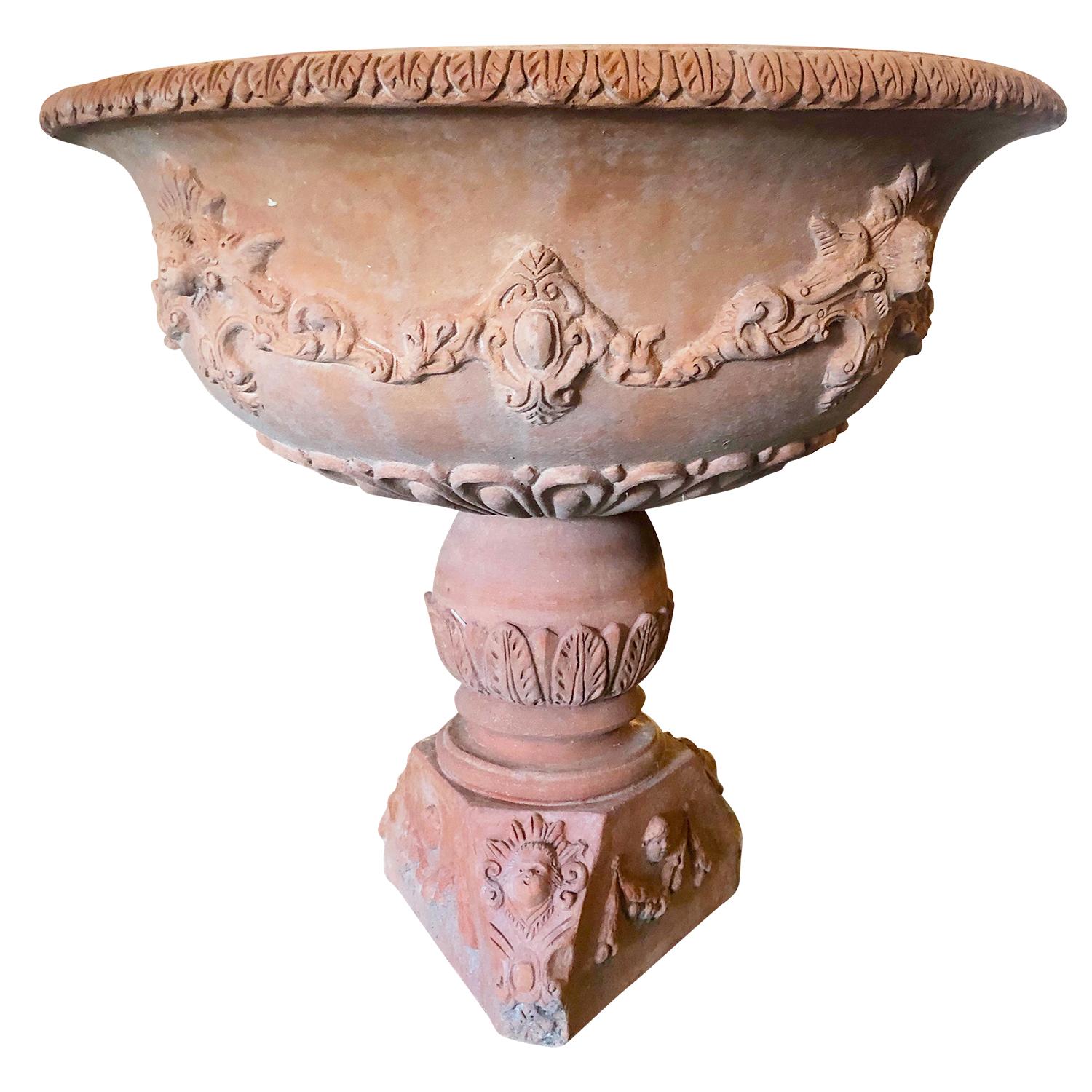 This Tuscan round terra cotta planter is full of extremely intricate details and mounted onto a hand-carved limestone base. This typical Renaissance-style urn includes shields, masks, and stags. This terra cotta garden planter from Naples, Italy can