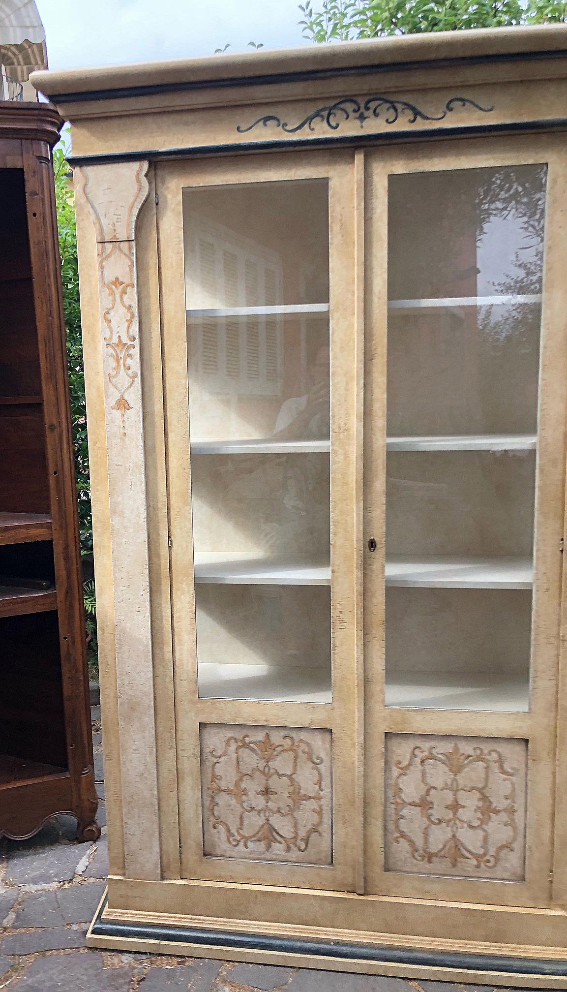 Italienisches Bücherregal aus Tanne, mit zwei Türen, handbemalt, mit Glas auf drei Seiten, Innenböden.
Sehr solide und elegant. 
In meinem Lager habe ich zwei dieser Bücherregale, wie auf den Fotos zu sehen.
Sie sind sich sehr ähnlich, gerade
