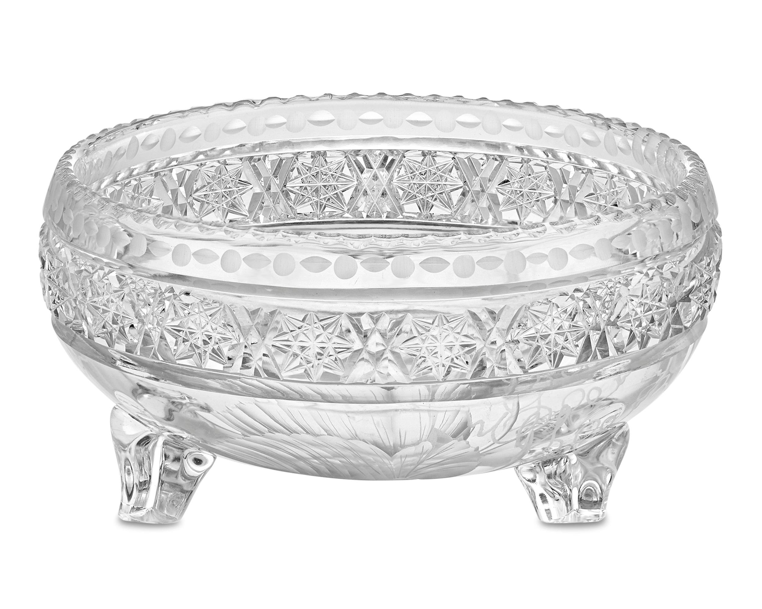 This impeccable cut glass bowl was crafted by famed American Brilliant maker Tuthill, in the company's desirable Vintage pattern. This exquisite dish is set upon three trefoil feet and adorned with this charming pattern's elegant design of cut