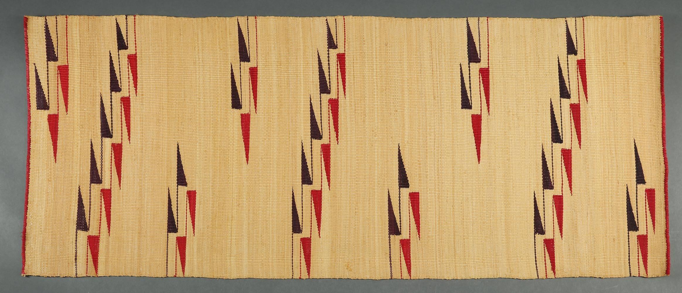 A strikingly modern geometric design woven flat mat by the Tutsi People of Rwanda, Africa. Red and black geometric design on a tan background. This decorative mat reflects the fine weaving quality the Tutsi are known for, similar to their popular
