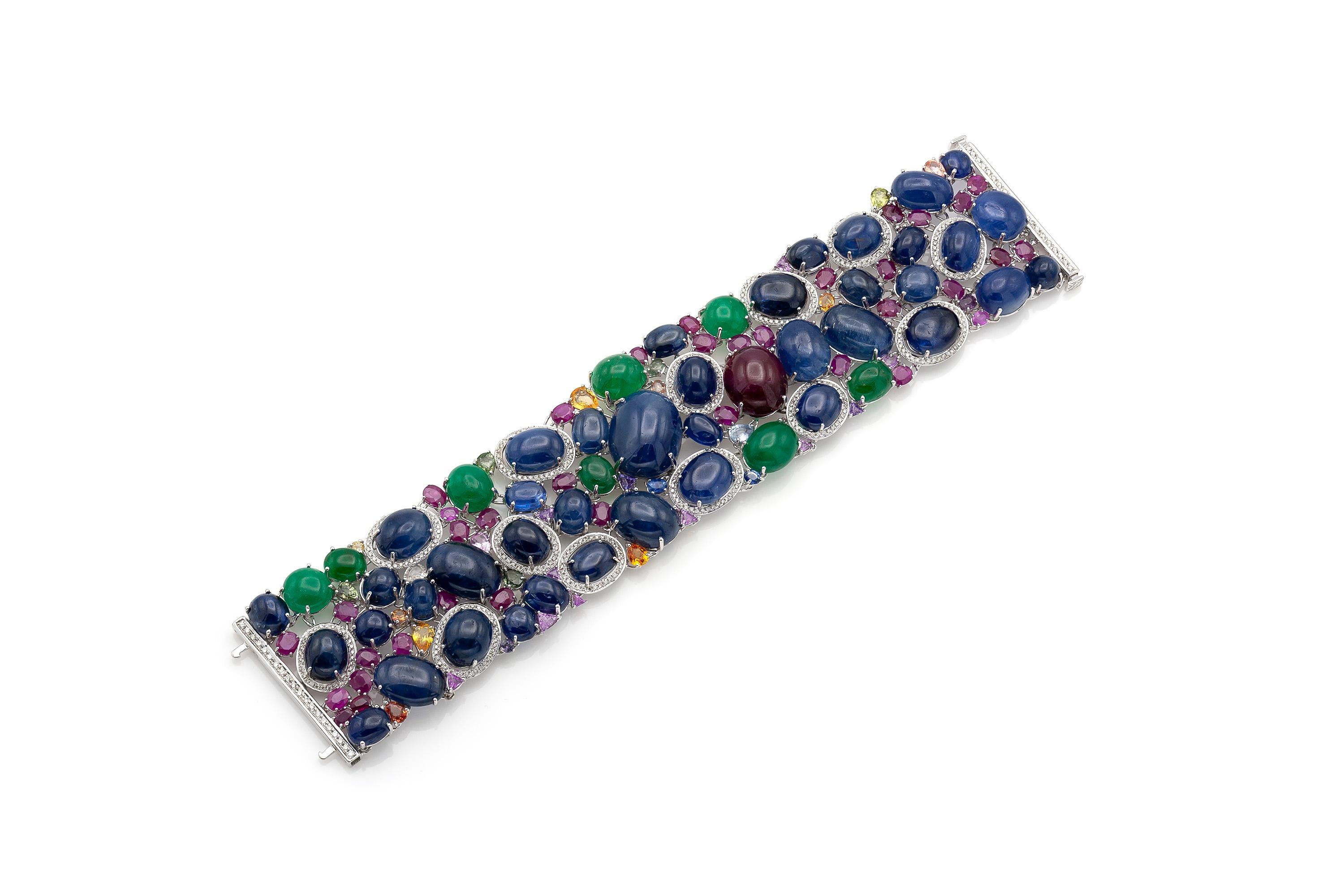 Finely crafted in 18k white gold with:
8 Cabochon Emeralds weighing a total of 29.43 carats
40 Cabochon Sapphires weighing a total of 270.26 carats
1 Cabochon Ruby weighing 36.14 carats
The bracelet features 473 diamonds weighing a total of