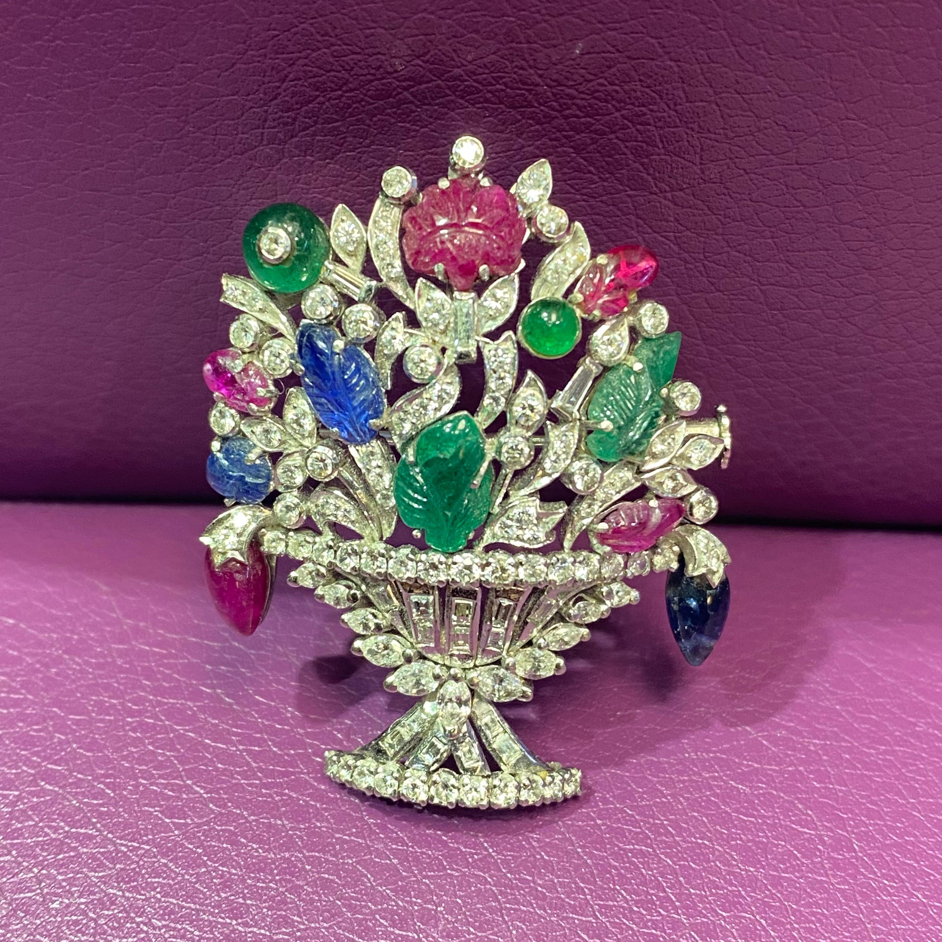 Tutti Frutti Diamond Giardinetto  Flower Basket Brooch 

A 18k white gold flower basket brooch including 2 carved & 2 round emeralds approximately 2.88 cts.  2 carved  & 1 pear shape sapphire approximately  2.18 cts.  4 carved rubies &  1 pear shape