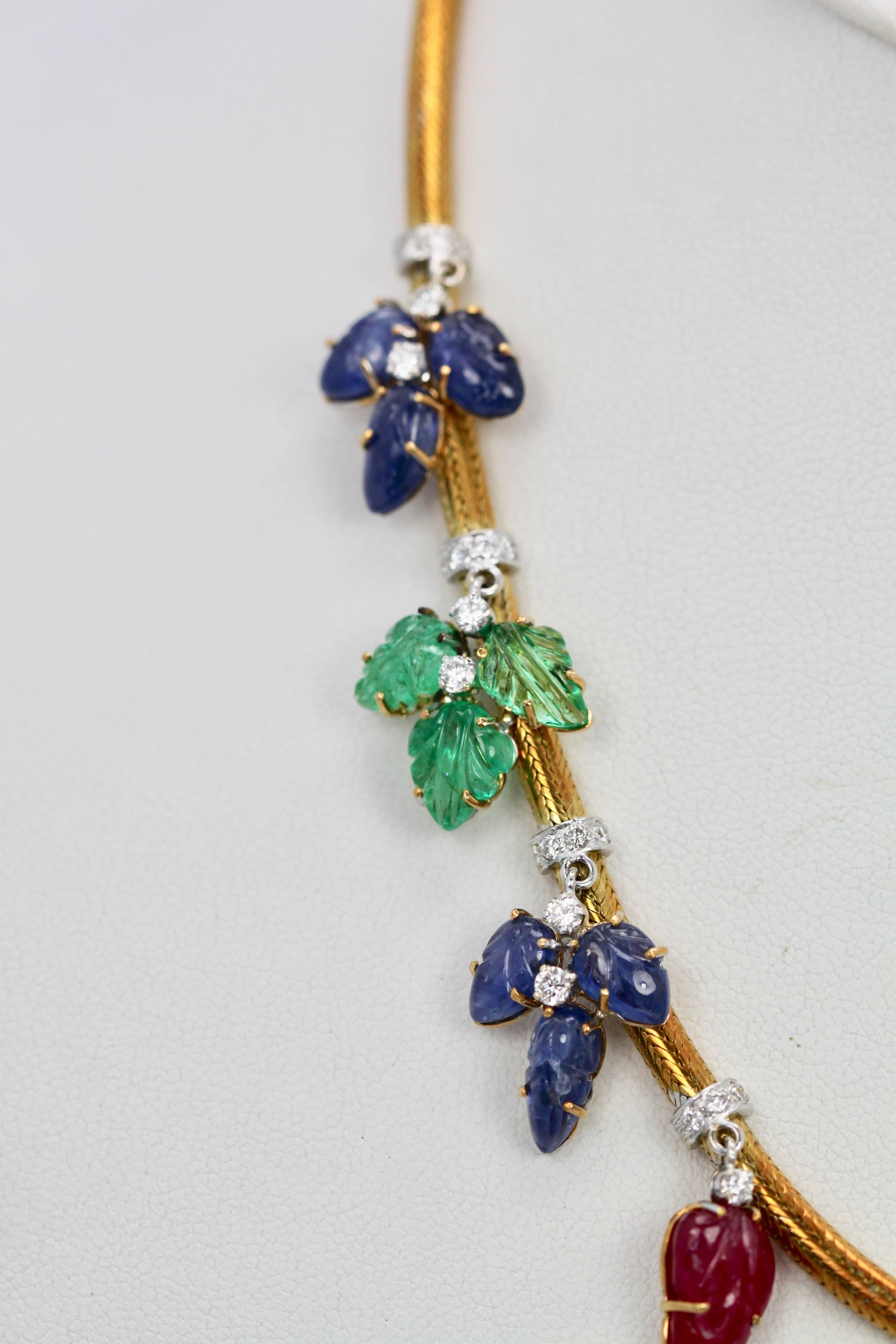 This  Necklace is from Italy circa 1950's it is 18K Yellow Gold Tubular necklace with carved gemstones leaves in Ruby, Emerald and Sapphire enhanced with Diamonds. 4 triple leaf Sapphires (12 in total) 4 triple leaf Emeralds (12 in total) 3 Ruby