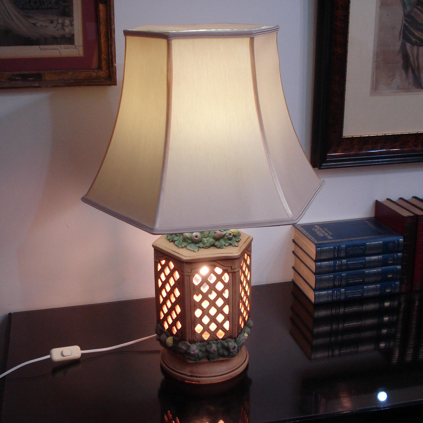 This is a very rare pair of ceramic, glazed, hand-painted table lamps, made in Italy in the 1960s-70s. They are richly decorated with fruits, feet in open work, and illuminated. They are in excellent original condition with no chips.
Original shades