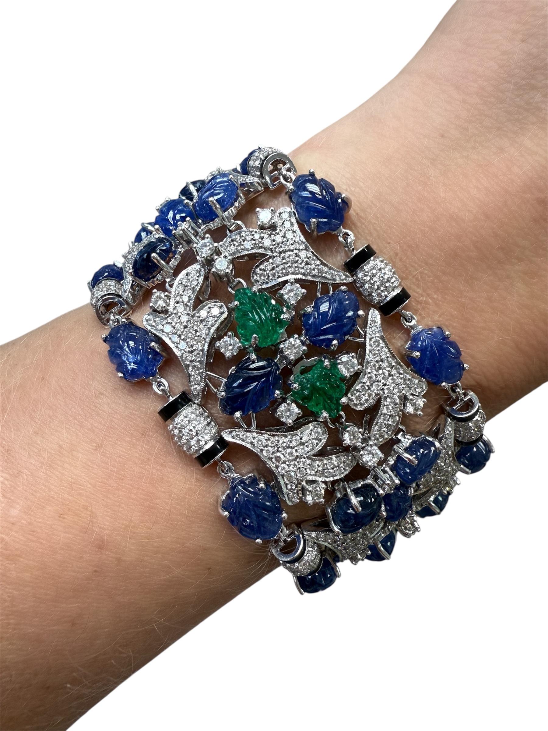 Questo splendido bracciale, nell'iconico stile Cartier Tutti Frutti, è decorato con un turbinio di zaffiri e smeraldi a foglia intagliati, accentuati da numerosi diamanti rotondi taglio brillante per un peso totale di circa 11,45 carati e smalto