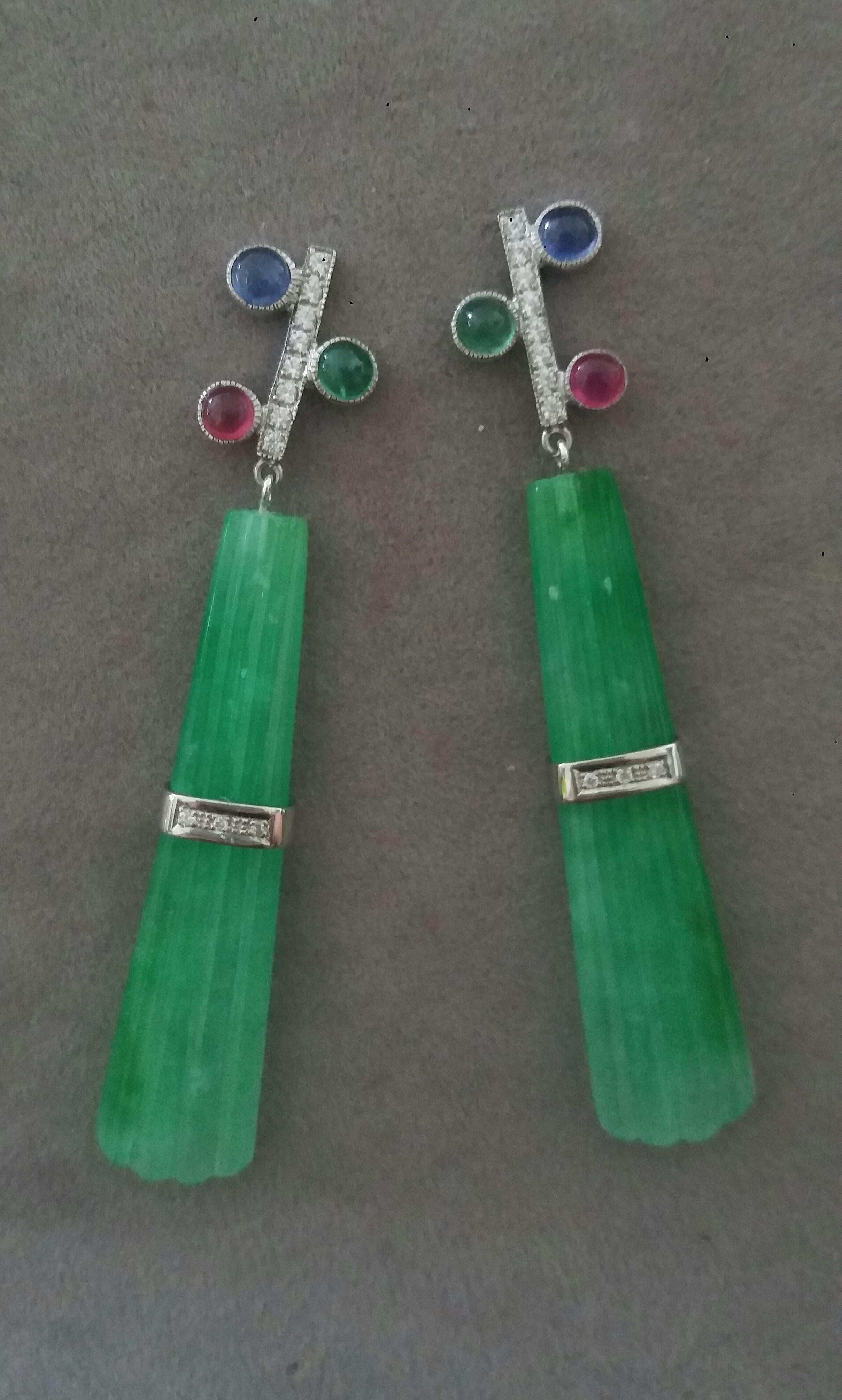 In these classic Tutti Frutti Style earrings the tops are 2 White Gold and  Diamonds Bars, 16 full brilliant cut diamonds ,and 3 pairs of  Rubies ,Emeralds and Blue Sapphires round cabs,in the lower parts we have 2 Engraved Jade  Drops measuring 12