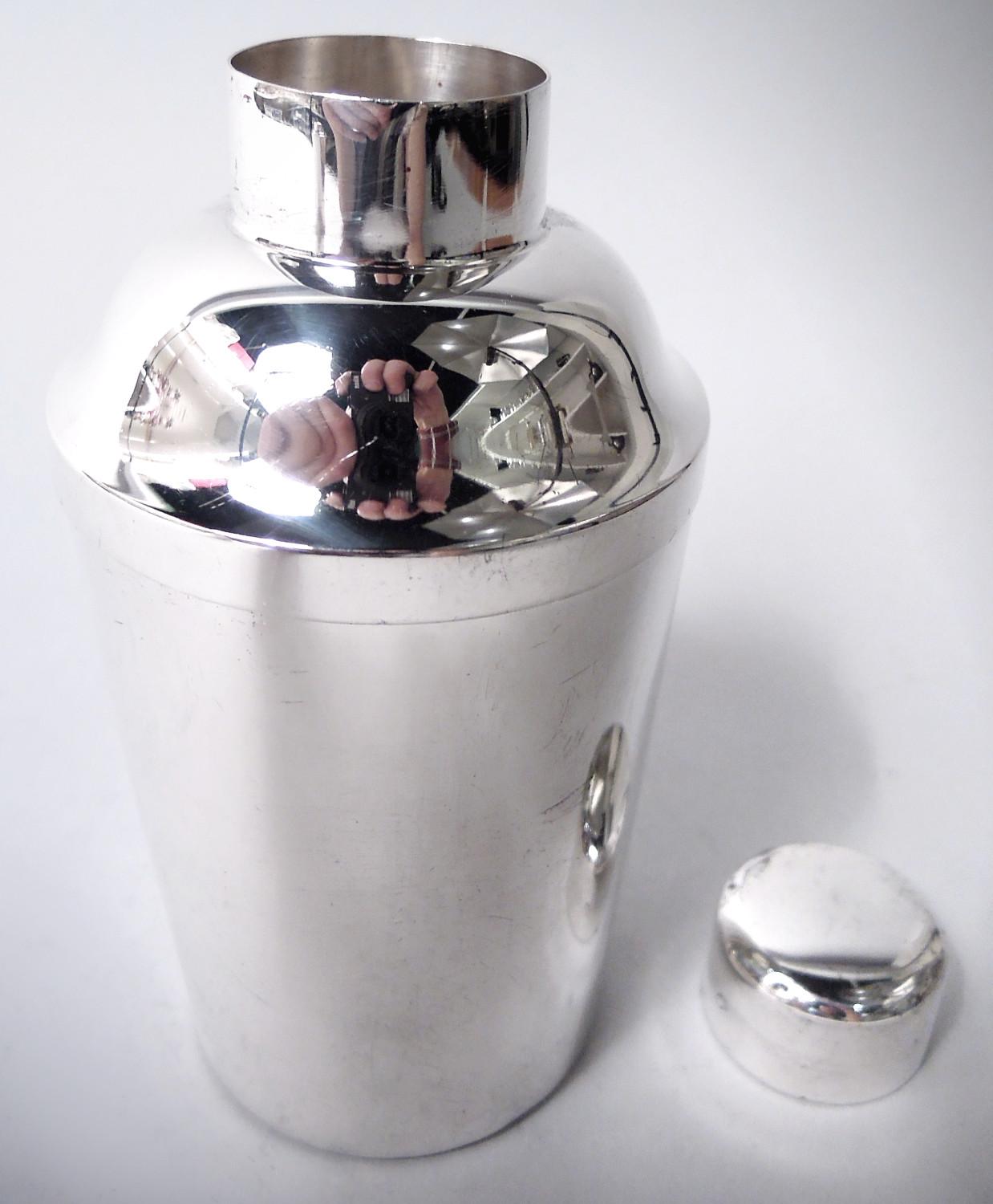 Moderna coctelera casera de plata de ley. Fabricado por Tuttle en Boston en 1941. Cazoleta recta y afilada y parte superior abovedada; cuello corto y recto con colador incorporado y tapón ajustado. Todo lo esencial a pequeña escala para una noche de