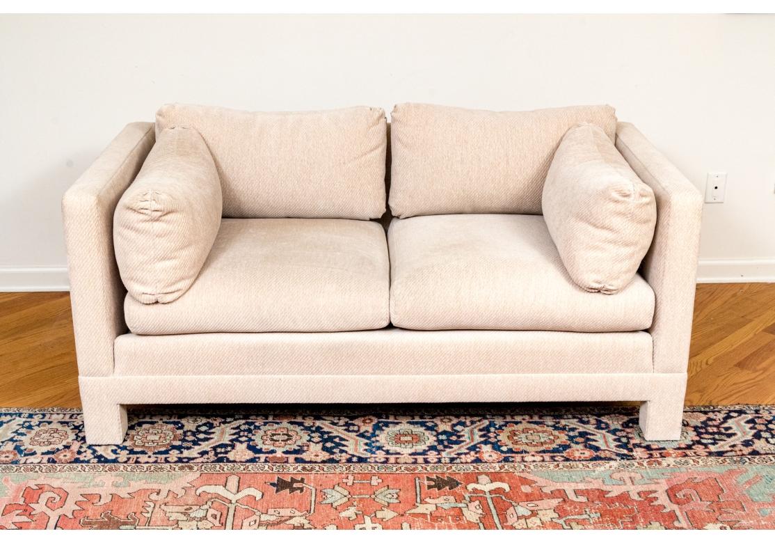 Fino Loveseat estilo esmoquin al estilo de Milo Baughman. Tapizada en color avena neutro, elevada sobre cuatro patas cuadradas tapizadas. Características del Loveseat  dos cojines sueltos para el asiento y el respaldo, acompañados de almohadas